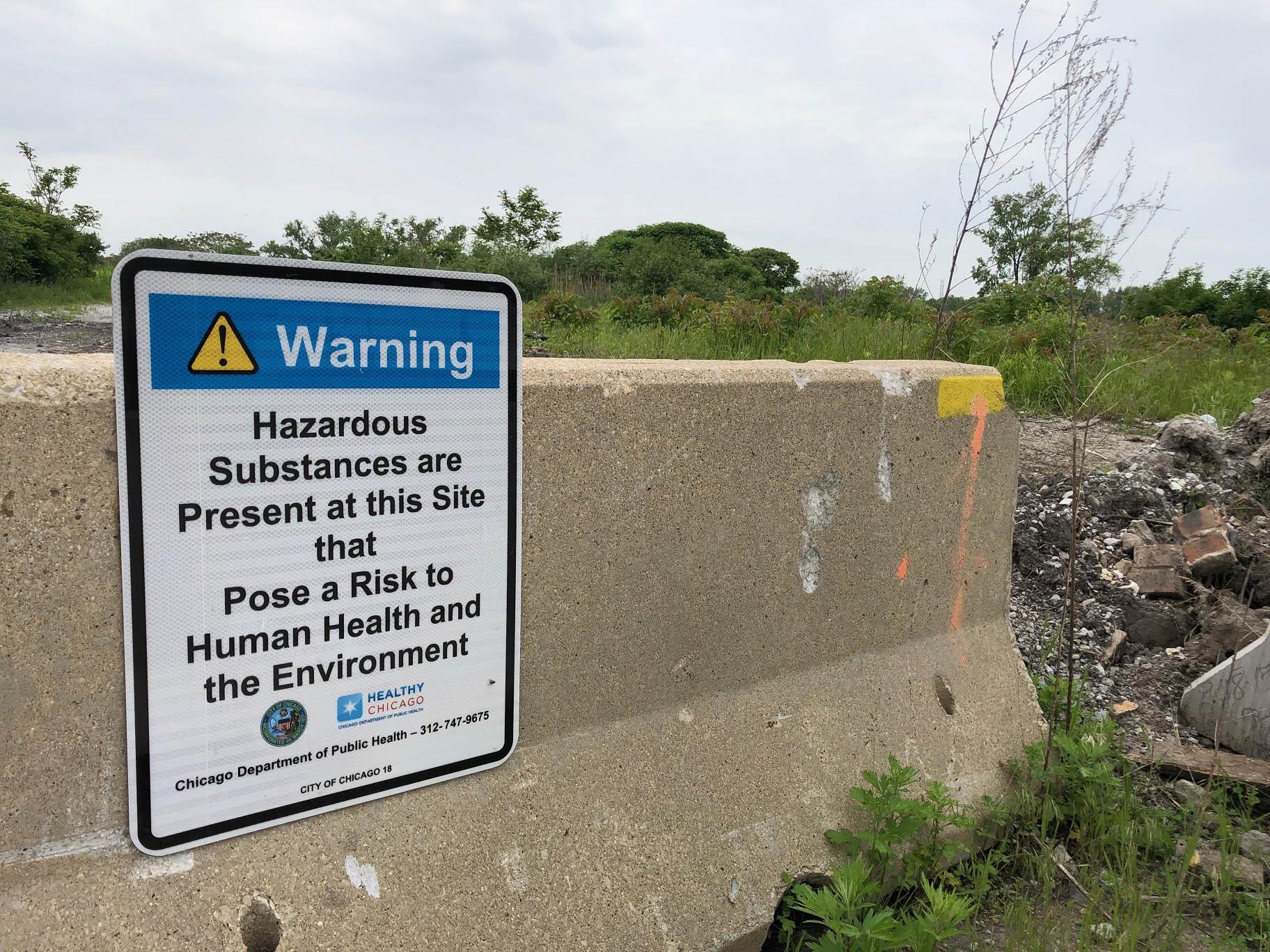 A Chicago Department of Public Health sign warns passersby about hazardous materials at a 67-acre property west of Wolf Lake at 126th Place and Avenue O. (Alex Ruppenthal / WTTW News)