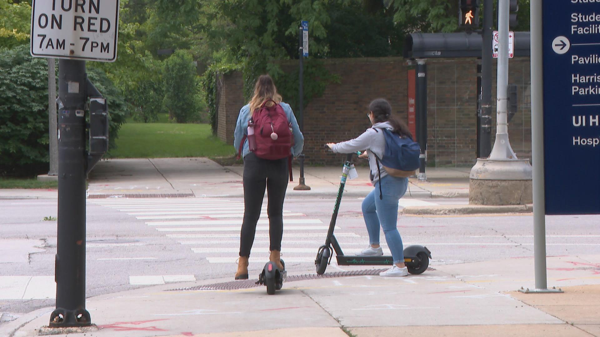 In this file photo, riders use electric scooters on the campus of the University of Illinois at Chicago. The city started its four-month scooter pilot program in June 2019. (WTTW News)