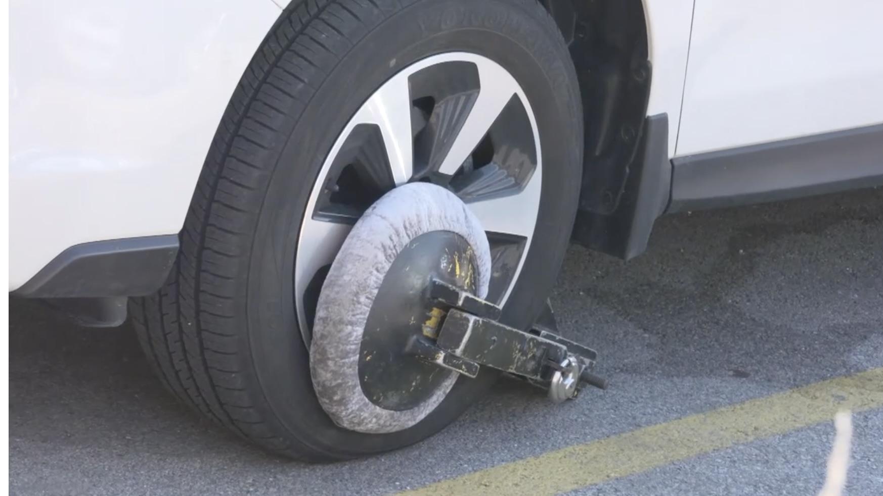 An Innovative Parking Solutions boot immobilizing a car in a North Side parking lot. (WTTW News)
