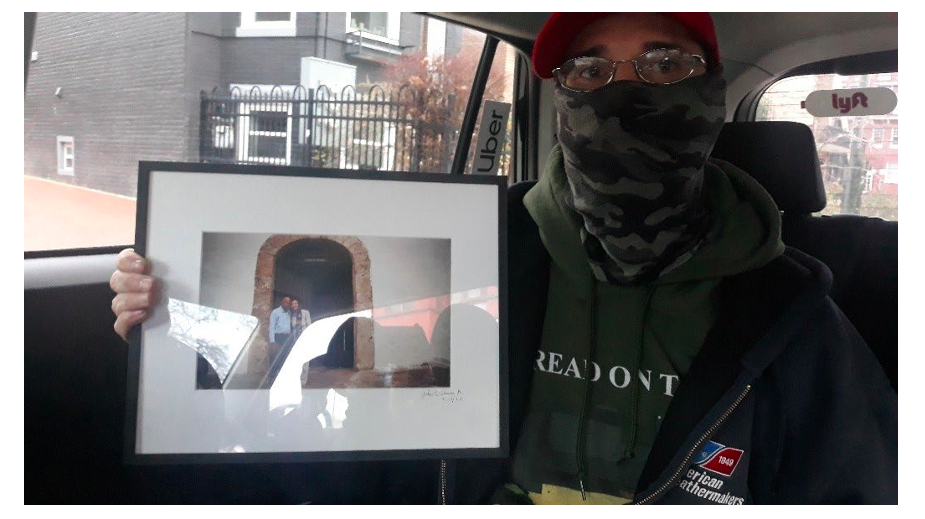 Kevin James Lyons holding a framed photo he was convicted of taking from House Speaker Nancy Pelosi’s office during the Jan. 6 insurrection. (U.S. Attorney’s Office)