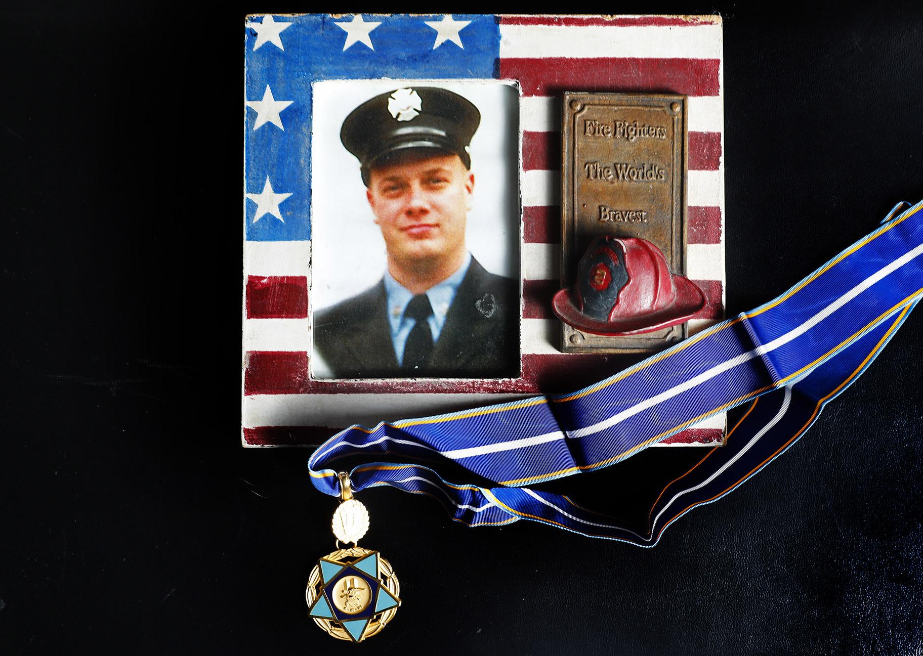 A photo of New York firefighter Christopher Michael Mozzillo, who died in the 9/11 attacks, with his 9/11 Medal of Valor is shown, Saturday, Sept. 7, 2024, in Freehold, N.J.. (AP Photo / Noah K. Murray)