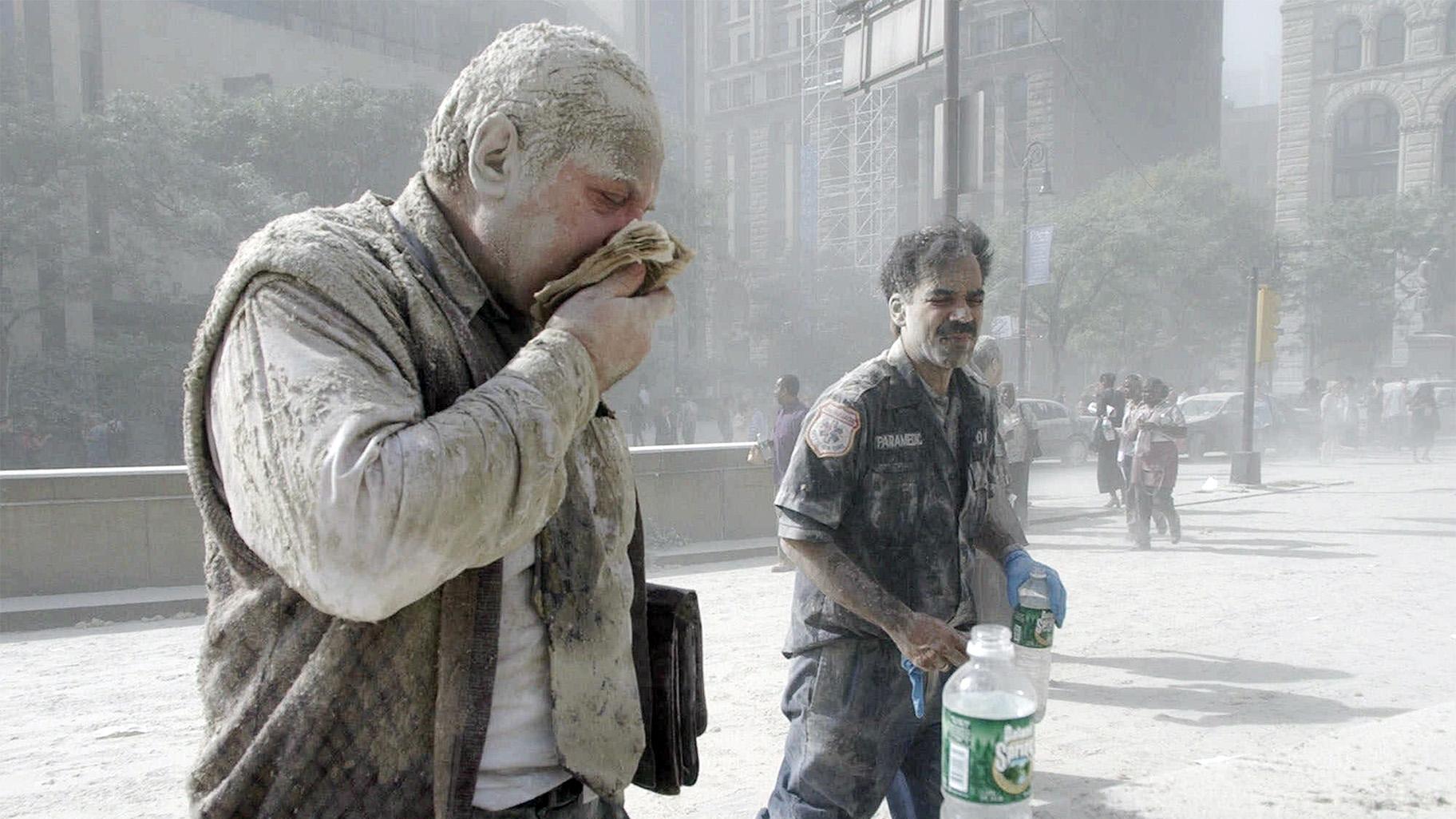 In this Sept. 11, 2001 file photo, a man coated with dust and debris from the collapse of the World Trade Center south tower coughs near City Hall, in New York.  (AP Photo / Amy Sancetta, File)