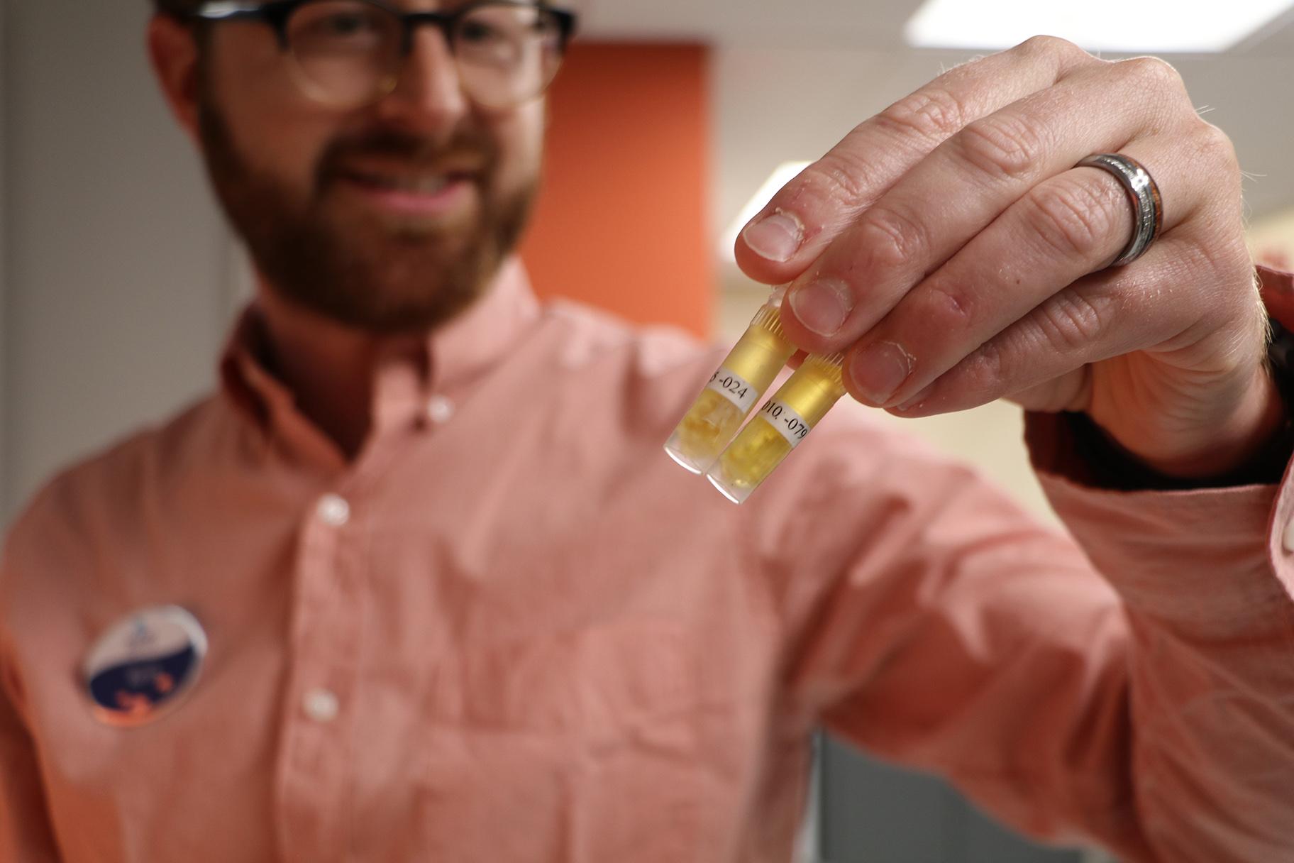 Coral reef biologist Ross Cunning holds two coral specimen collected from the Abaco Islands in the northern Bahamas. (Evan Garcia / WTTW News)