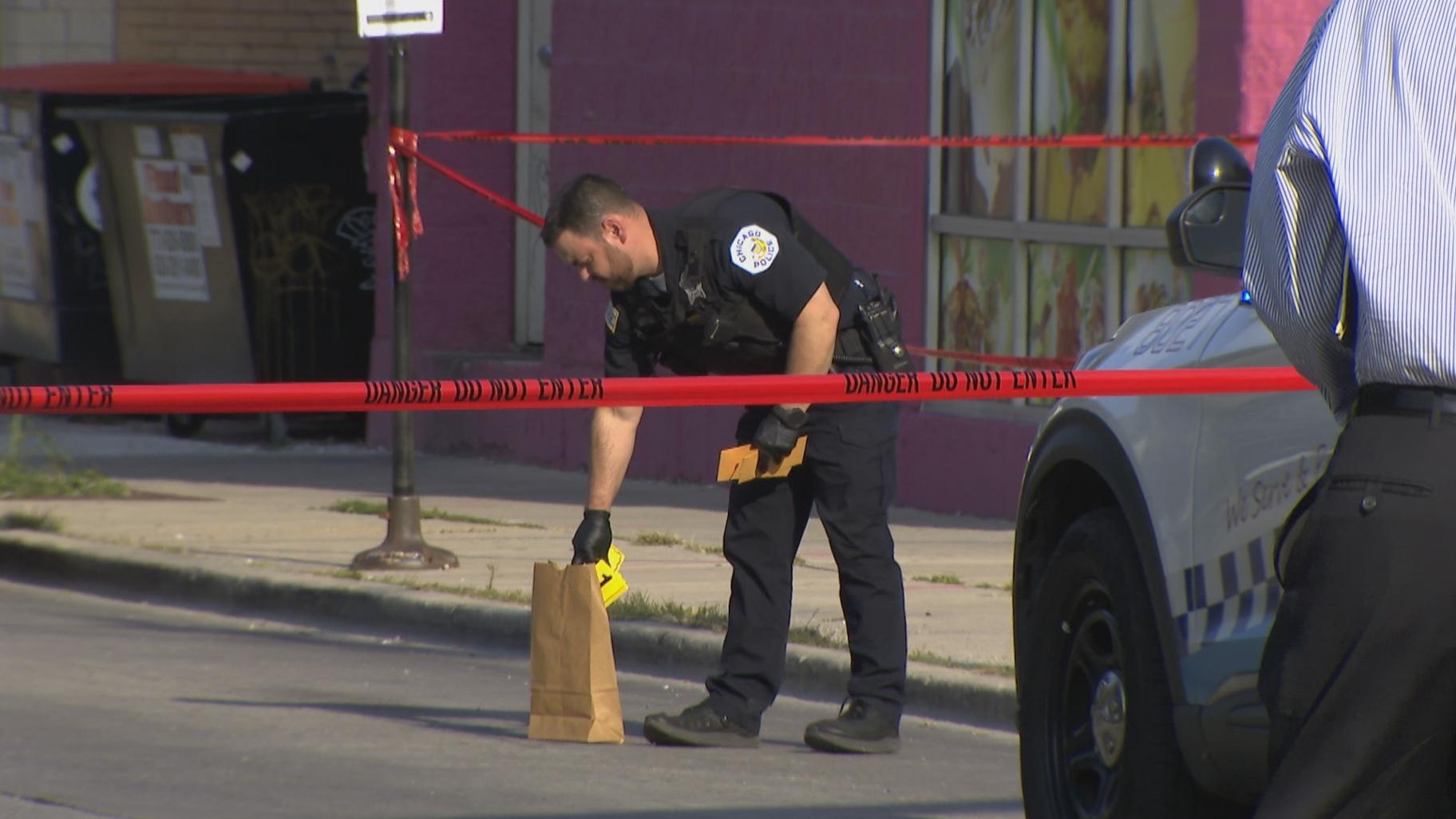 A Chicago Police officer places evidence markers at the scene of a shooting in the 4300 block of West Addison near Schurz High School on Aug. 24, 2022. (WTTW News)
