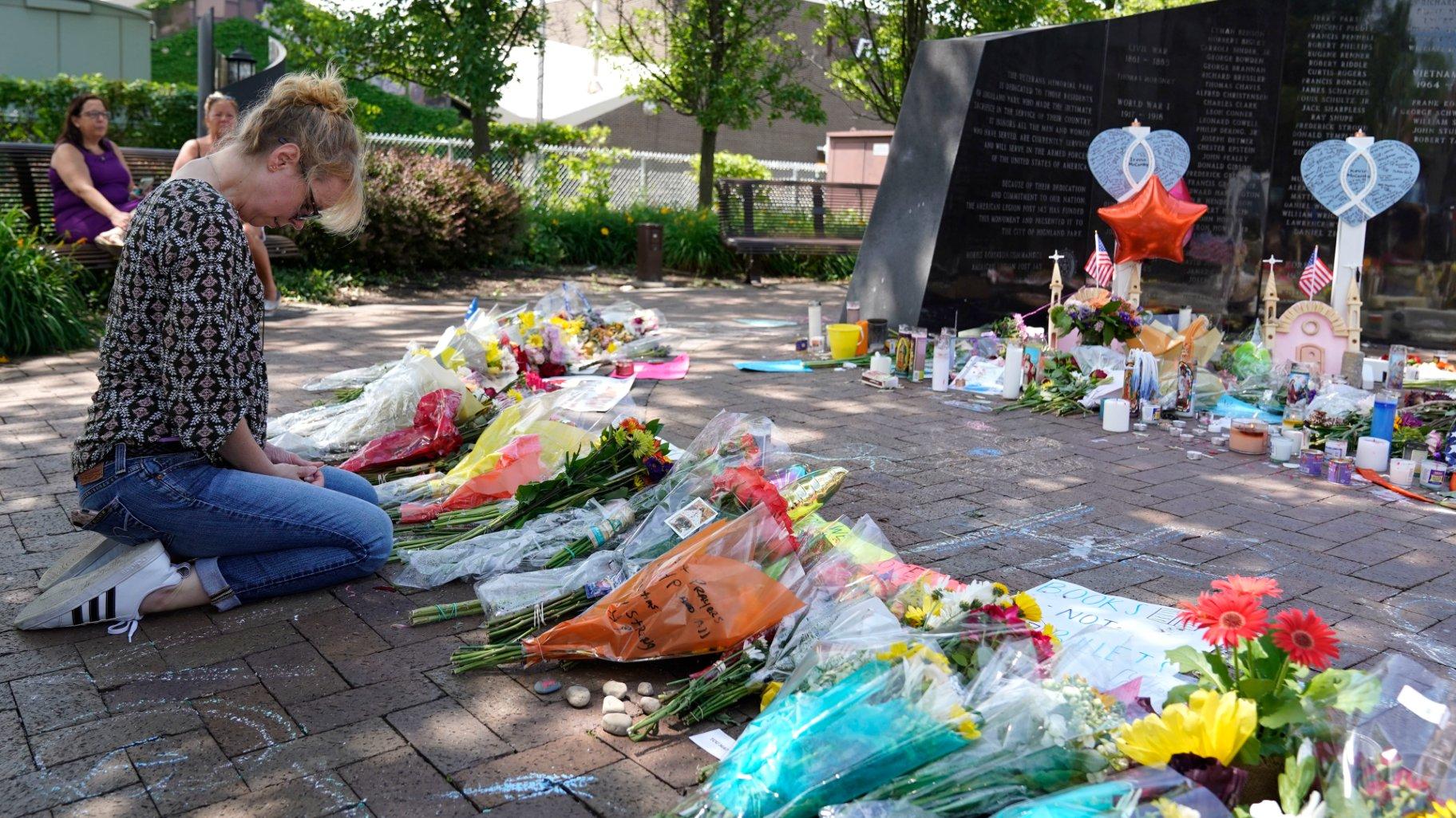 FILE - A visitor prays at a memorial to the seven people killed and others injured in the Fourth of July mass shooting at the Highland Park War Memorial in Highland Park, Ill., July 7, 2022. (Nam Y. Huh / AP Photo, File)