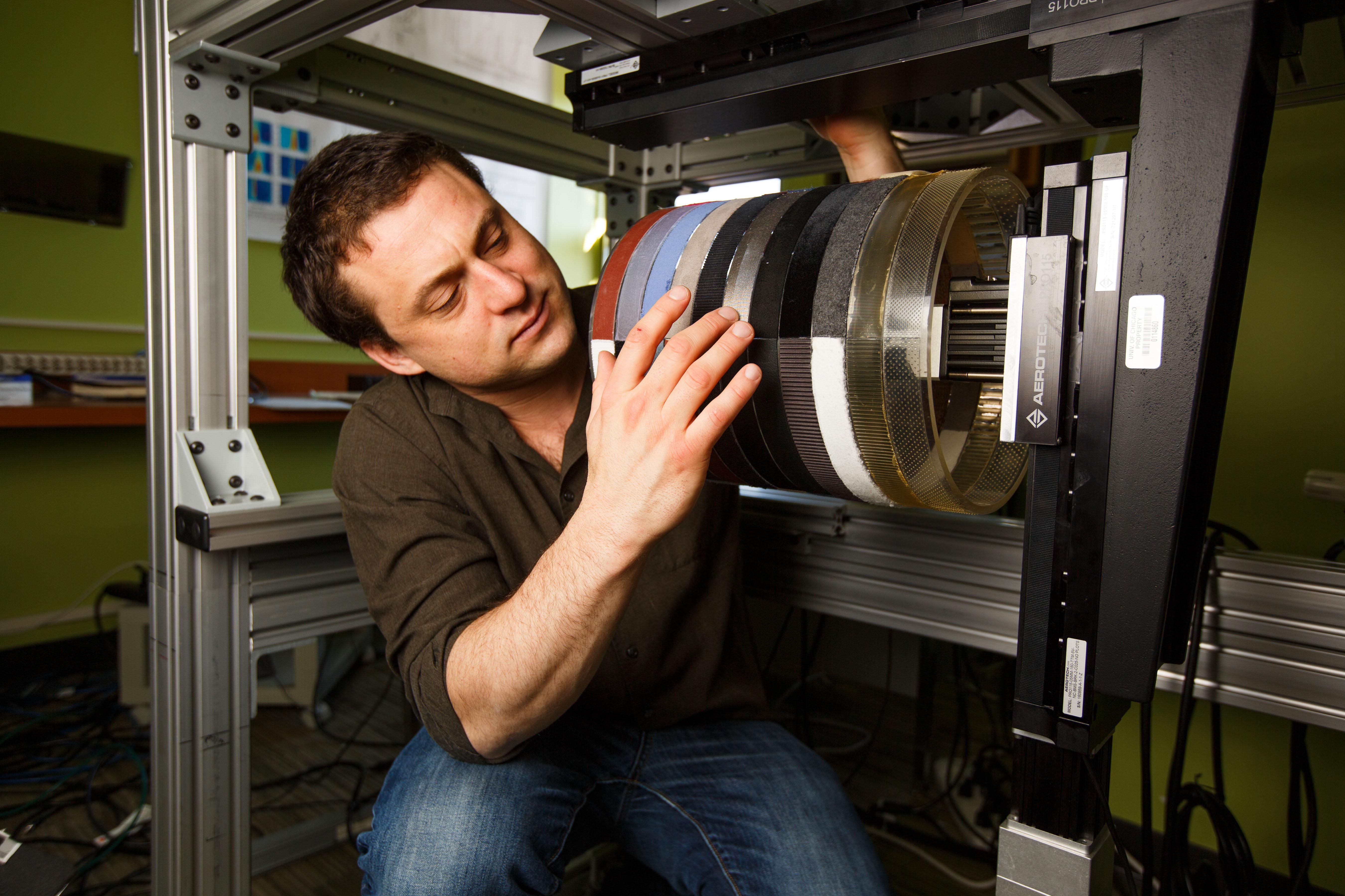 Sliman Bensmaia touches a rotating drum covered with different textures used for research. Human subjects hold their finger against it and report different sensations as different materials touch their skin. (Jason Smith / University of Chicago)