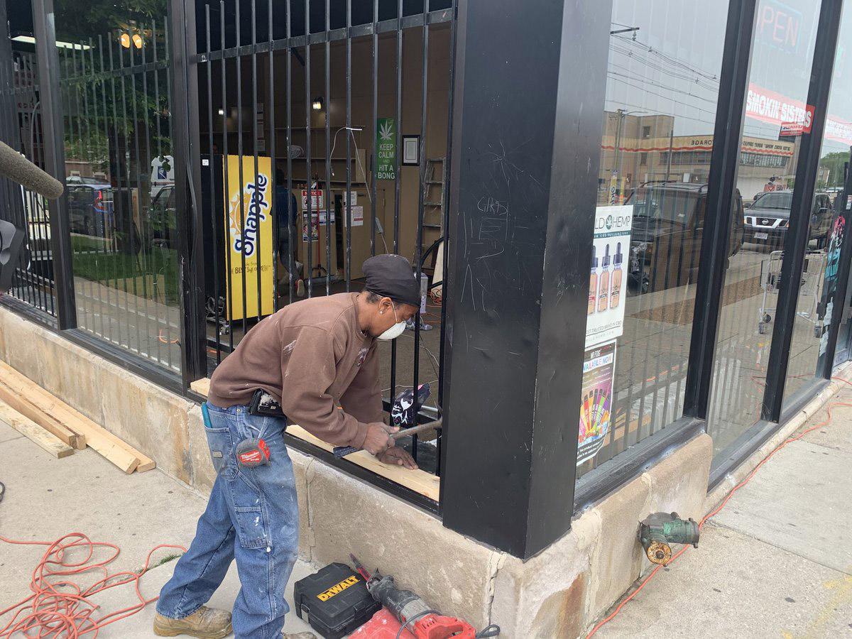 Crews start boarding up the 3 Smokin Sisters Tobacco Shop on 71st Street in Chicago’s South Shore neighborhood. Shop owners emptied the store of inventory following looting on Sunday, May 31, 2020. (@paschutz / Twitter)