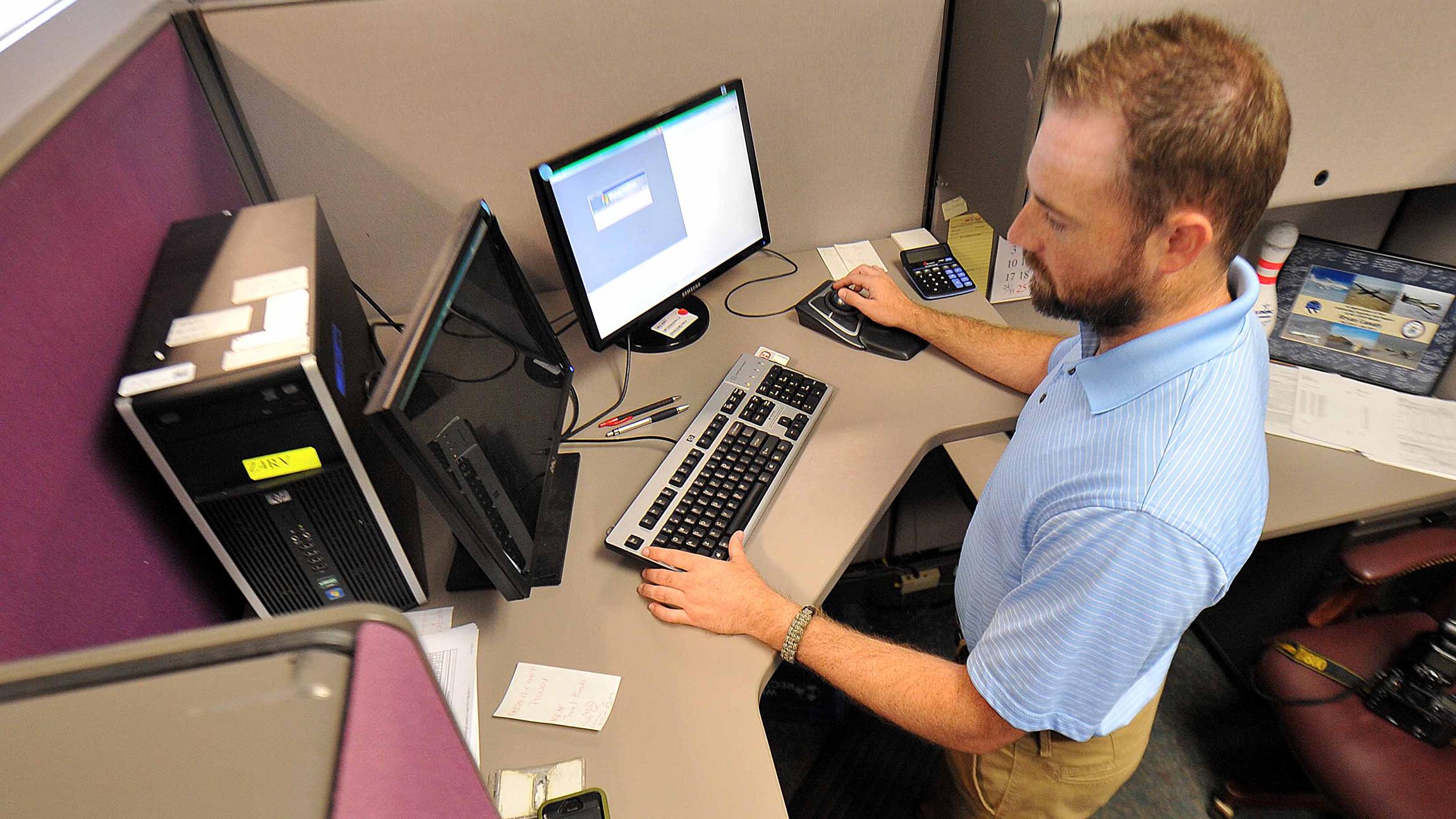 Bryan Canady, Air Force Life Cycle Management Center contracting specialist, performs his job while standing at the computer. (Tommie Horton / U.S. Air Force) 
