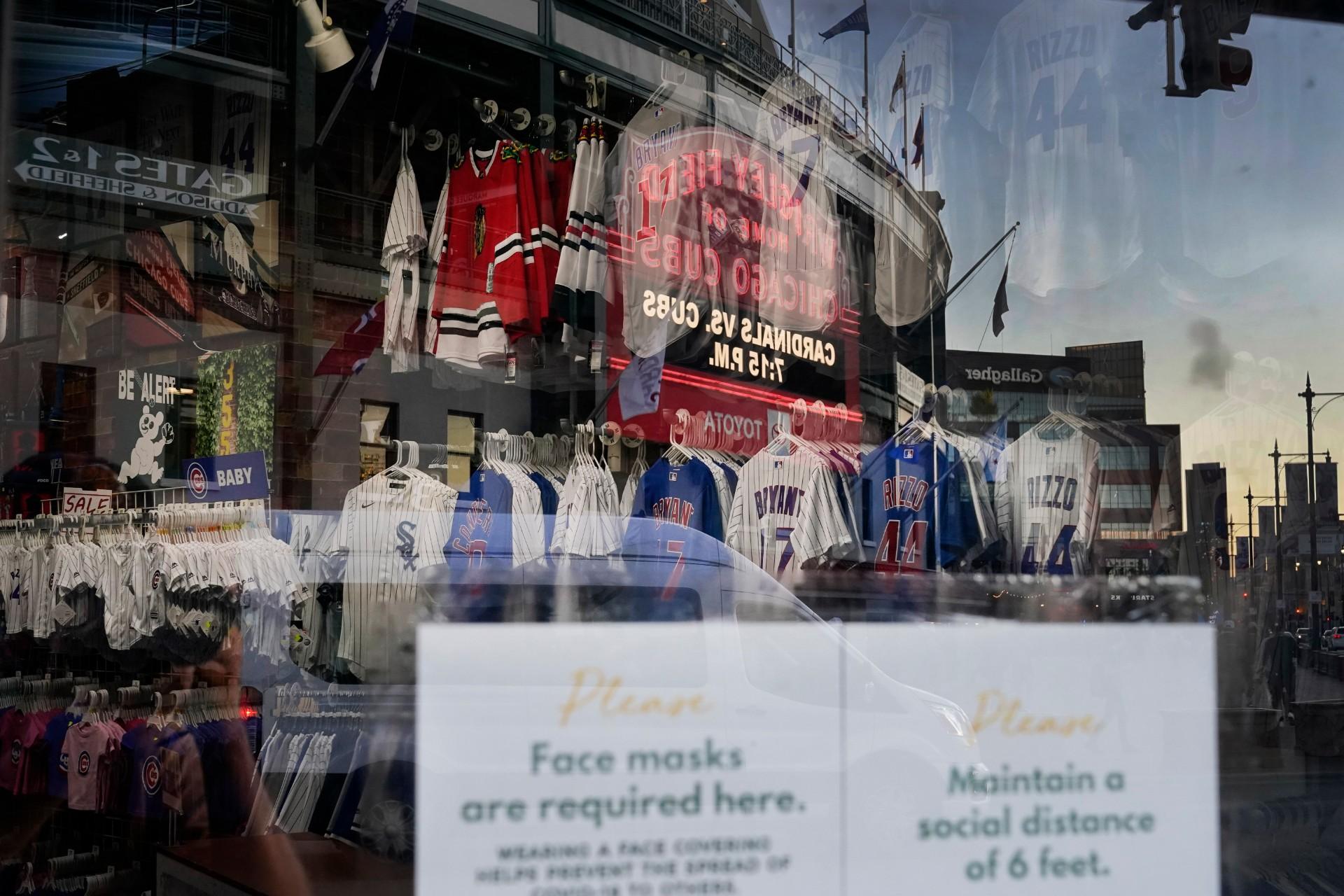The Wrigley Field marquee is reflected Friday, Sept. 4, 2020, in the window of the Sports World apparel store in the Wrigleyville neighborhood of Chicago. (AP Photo / Charles Rex Arbogast)
