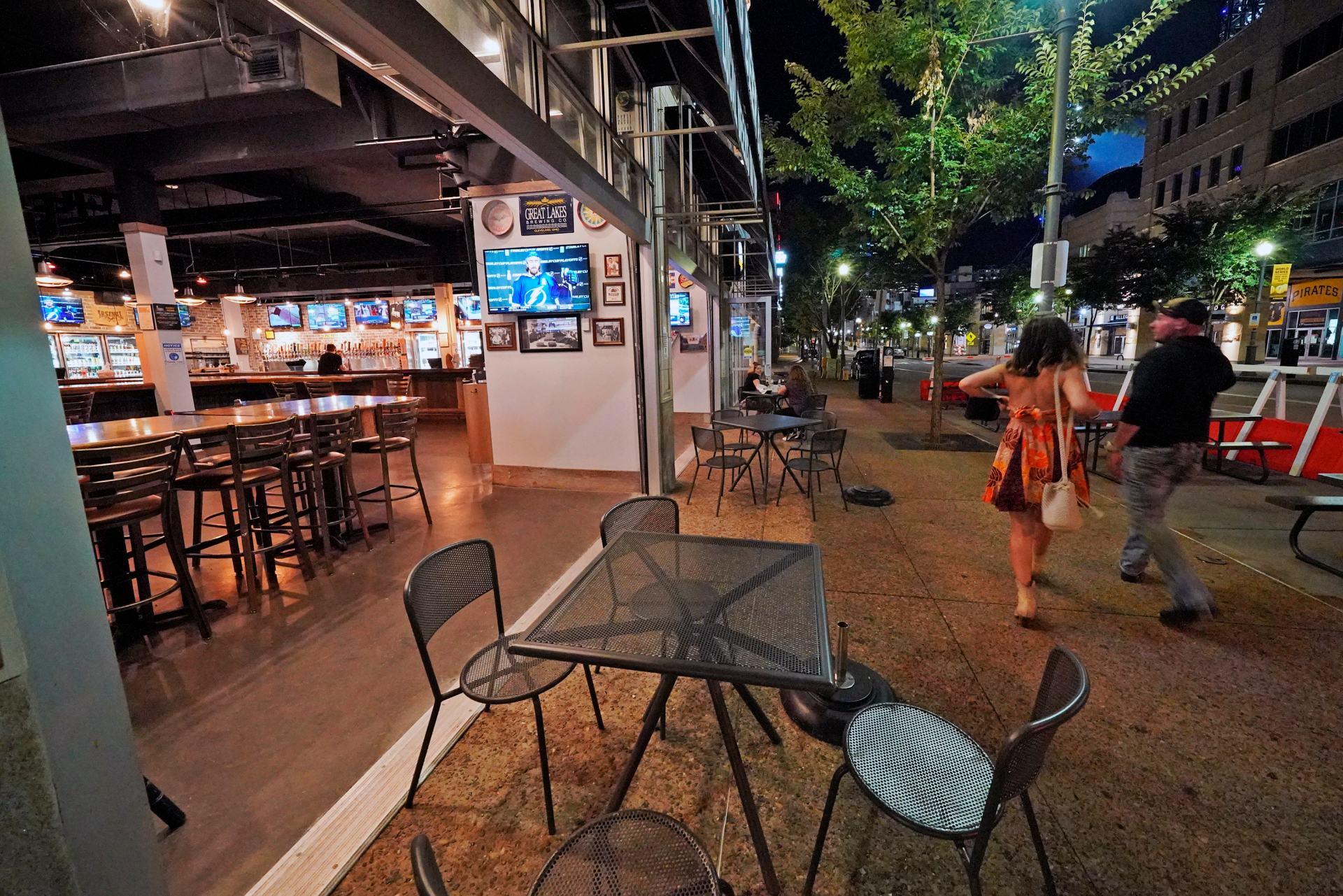 In this Sept, 9, 2020, file photo, a couple walk past Mike's Beer Bar, across the street from PNC Park, after a baseball game between the Chicago White Sox and Pittsburgh Pirates in Pittsburgh. (AP Photo / Gene J. Puskar, File)