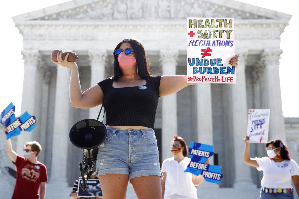 Terrisa Bukovinac, founder of Pro-Life San Francisco, holds a model of a fetus as she and other anti-abortion protesters wait outside the Supreme Court for a decision, Monday, June 29, 2020. (AP Photo / Patrick Semansky)