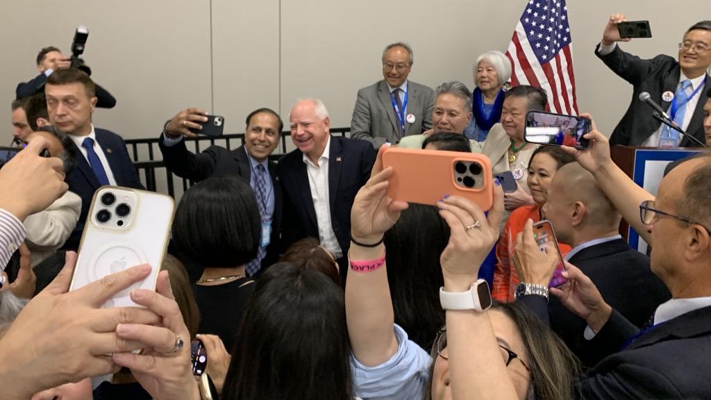 U.S. Rep. Raja Krishnamoorthi (D-IL) takes a photo with Democratic vice presidential pick and Minnesota Gov. Tim Walz during an AAPI Caucus meeting during the DNC at McCormick Place on Aug. 19, 2024. (Eunice Alpasan / WTTW News)