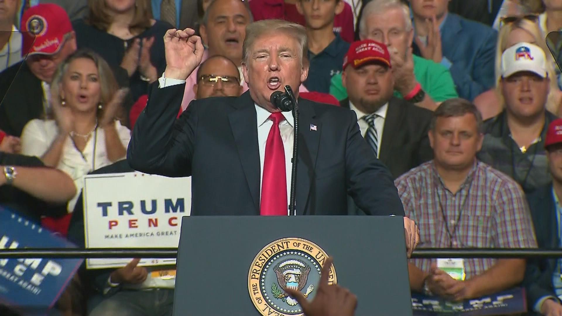 President Donald Trump addresses a crowd of supporters at a campaign rally-style event. 