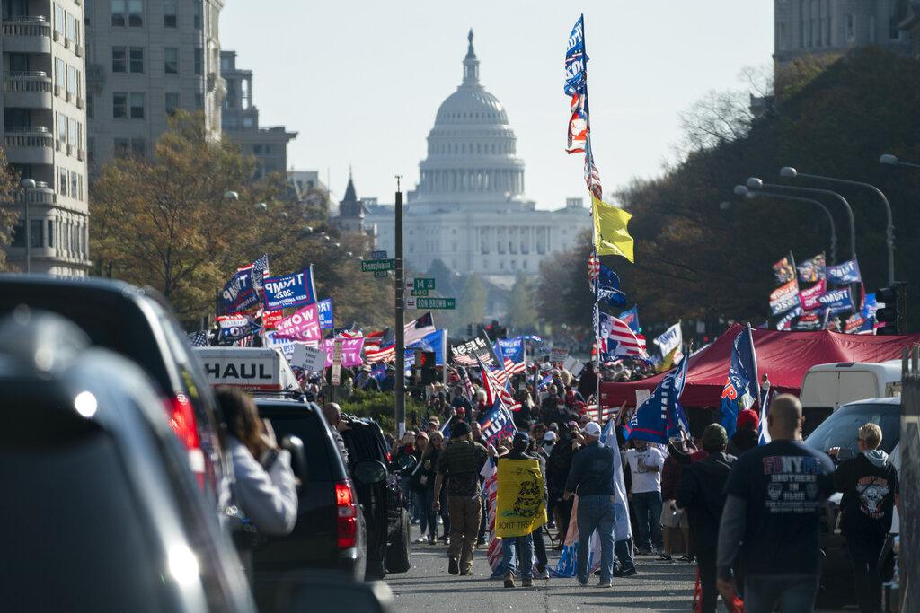 A motorcade carrying President Donald Trump drives by a group of supporters participating in a rally near the White House, Saturday, Nov. 14, 2020, in Washington. (AP Photo / Evan Vucci)