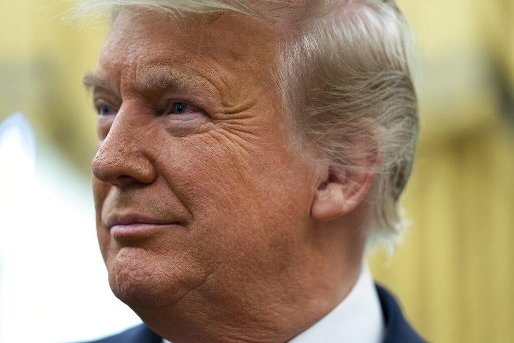 President Donald Trump listens during a ceremony to present the Presidential Medal of Freedom to former football coach Lou Holtz, in the Oval Office of the White House, Thursday, Dec. 3, 2020, in Washington. (AP Photo / Evan Vucci)