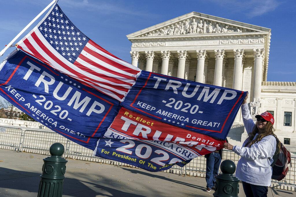 Kathy Kratt of Orlando, Fla., displays her Trump flags as she and other protesters demonstrate their support for President Donald Trump at the Supreme Court in Washington, Friday, Dec. 11, 2020. (AP Photo / J. Scott Applewhite)