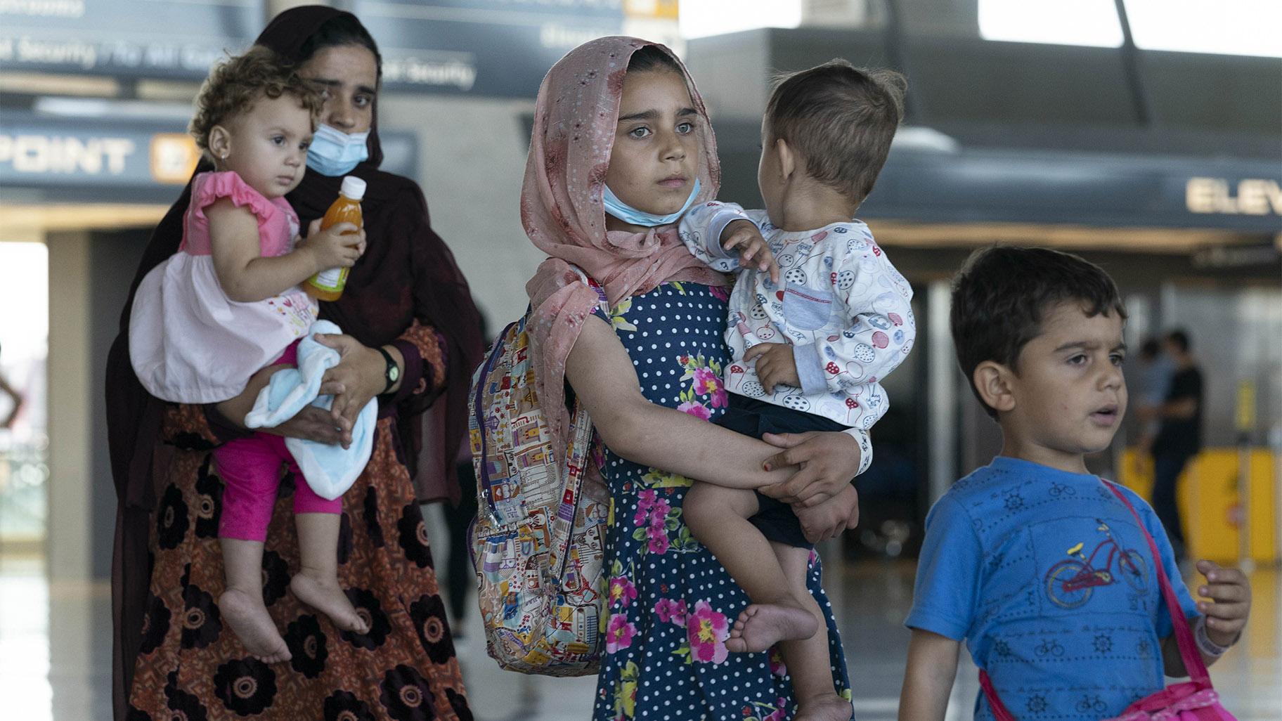 Families evacuated from Kabul, Afghanistan, walk through the terminal before boarding a bus after they arrived at Washington Dulles International Airport, in Chantilly, Va., on Thursday, Sept. 2, 2021. (AP Photo / Jose Luis Magana)