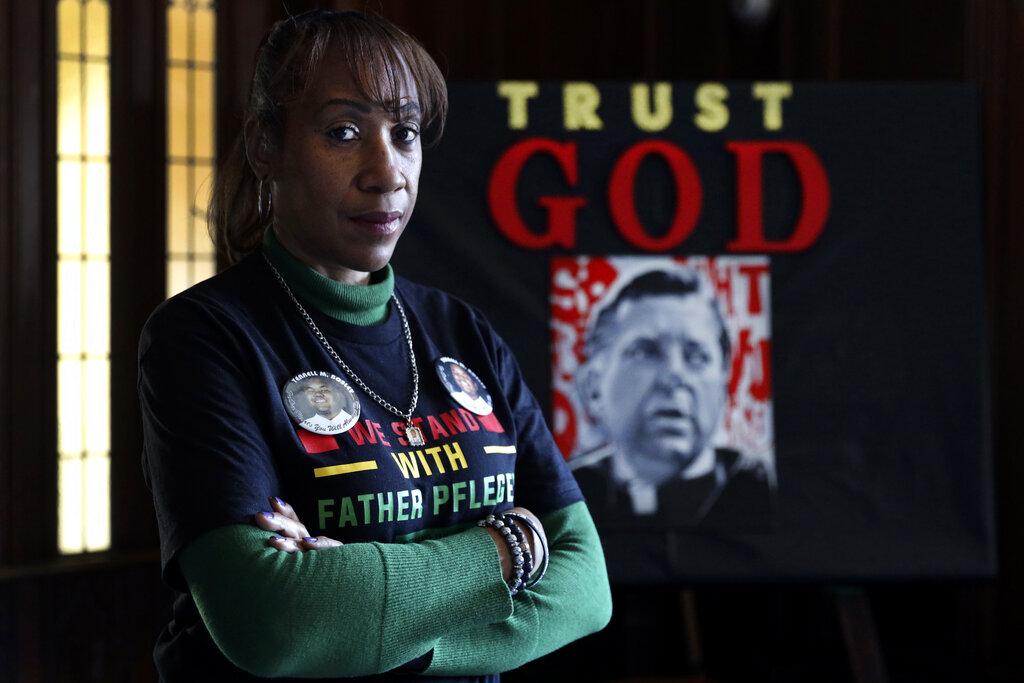 Activist Pam Bosley poses for a portrait in front of a portraiture of Father Michael Pfleger, inside the St. Sabina Catholic Church on Thursday, March 4, 2021, in Chicago. (AP Photo / Shafkat Anowar)