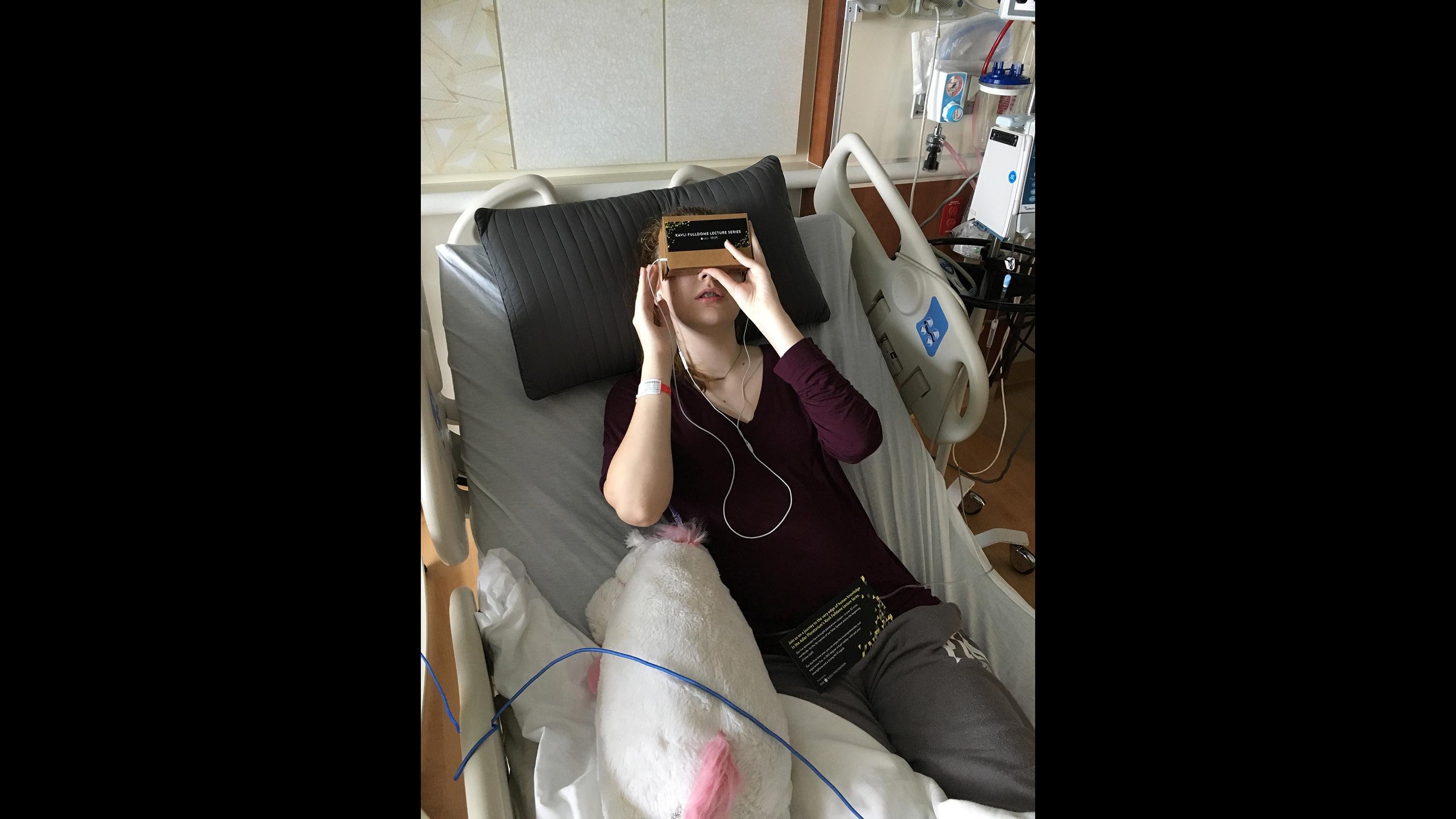 A patient at Lurie Children’s Hospital watches a Kavli Fulldome Lecture Series presentation in 2016 on a Google Cardboard device provided by Adler Planetarium. (Courtesy Lurie Children’s Hospital)