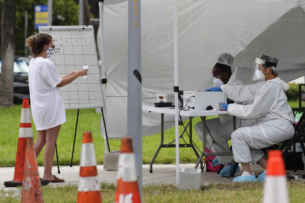 In this Friday, July 17, 2020 file photo, health care workers take information from people in line at a walk-up COVID-19 testing site during the coronavirus pandemic in Miami Beach, Fla. (AP Photo / Lynne Sladky)