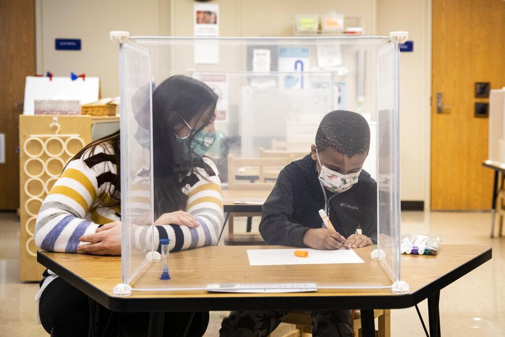 In this Jan. 11, 2021 file photo, pre-kindergarten teacher Sarah McCarthy works with a student at Dawes Elementary in Chicago. (Ashlee Rezin Garcia / Chicago Sun-Times via AP, Pool, File)