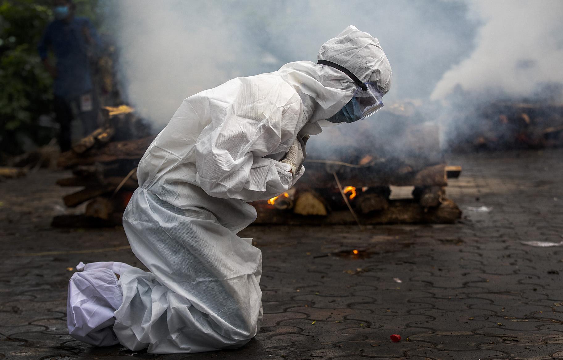 In this July 2, 2021, file photo, a woman breaks down as she prays before the cremation of a relative who died of COVID-19 in Gauhati, India. (AP Photo / Anupam Nath, File)