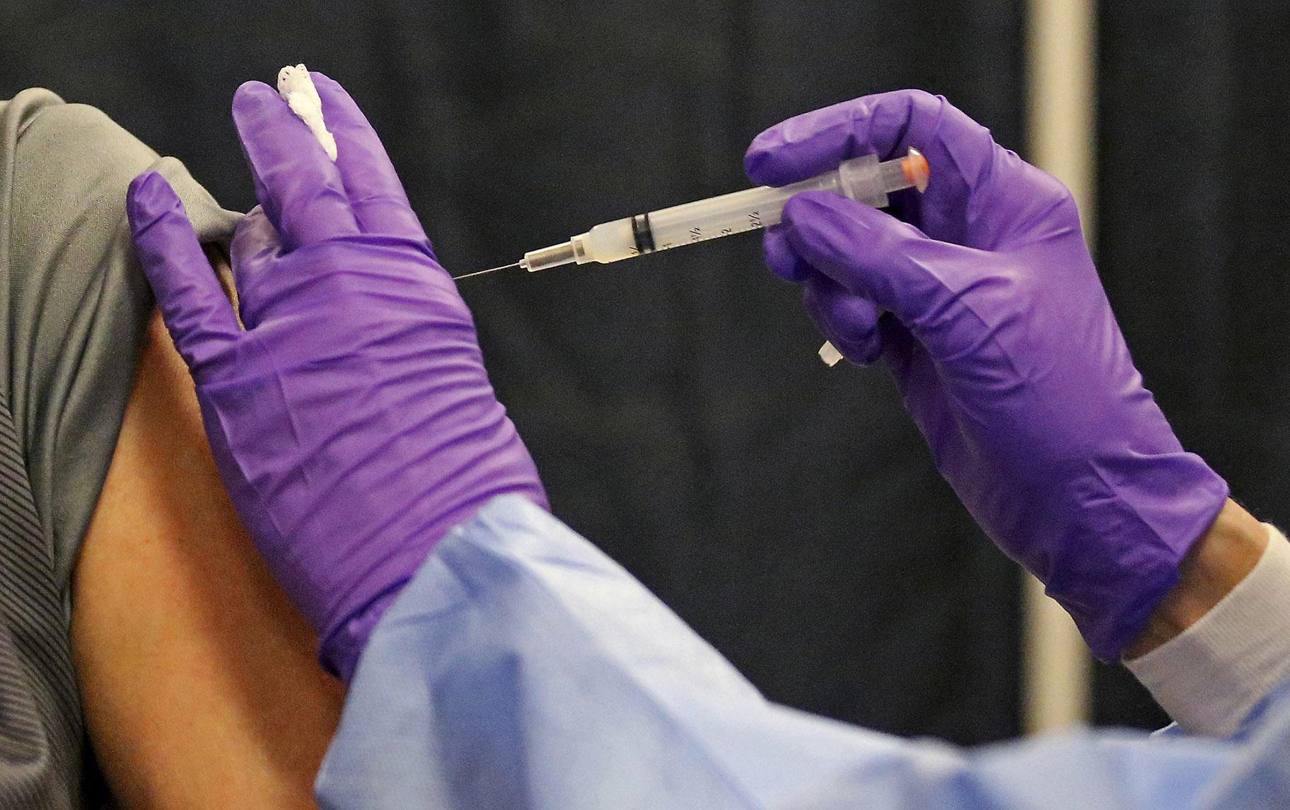 A man gets a COVID-19 vaccine at a mass vaccination site at the Natick Mall on Wednesday, Feb. 24, 2021, in Natick, Mass. (Matt Stone / The Boston Herald via AP, Pool)