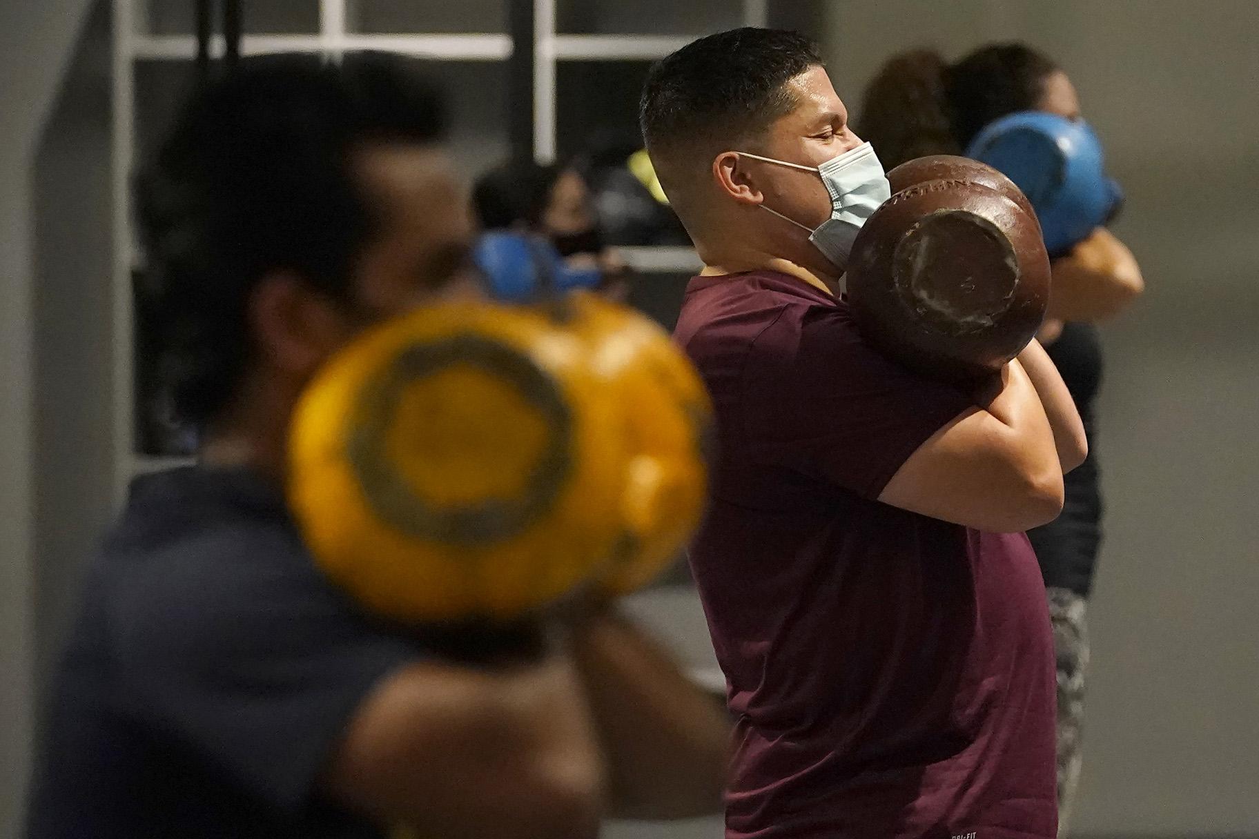 In this Nov. 24, 2020, file photo, Juan Avellan, center, and others wear masks while working out in an indoor class at a Hit Fit SF gym amid the coronavirus outbreak in San Francisco. (AP Photo / Jeff Chiu, File)