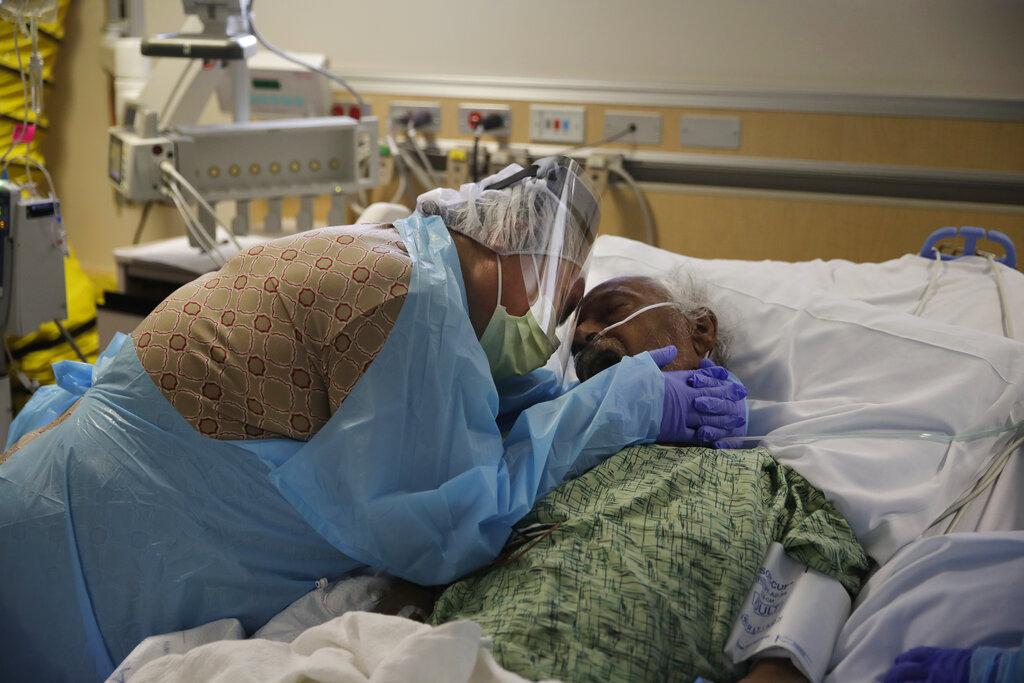 In this July 31, 2020, file photo, Romelia Navarro, 64, weeps while hugging her husband, Antonio, in his final moments in a COVID-19 unit at St. Jude Medical Center in Fullerton, Calif. (AP Photo / Jae C. Hong, File)