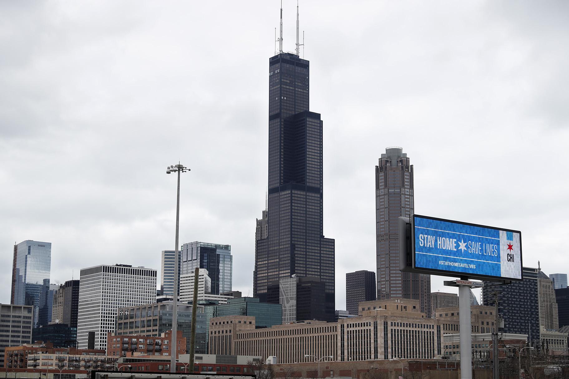 A public service message reading Stay Home Saves Lives is seen against the Chicago skyline Monday, March 30, 2020. (AP Photo/ Charles Rex Arbogast)