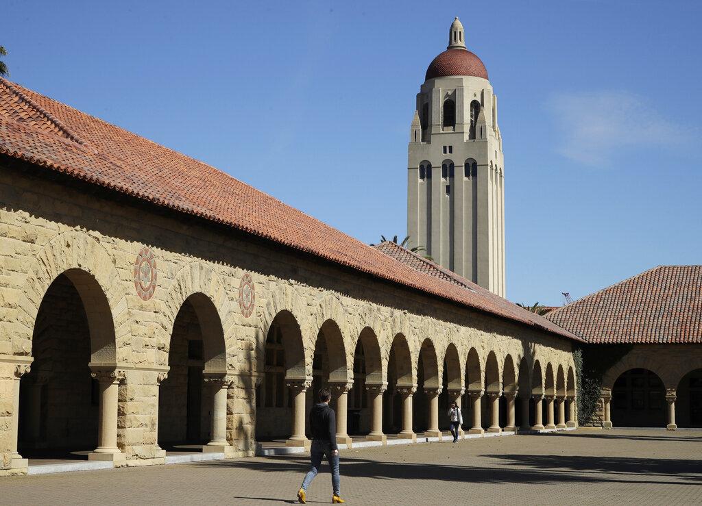 In this March 14, 2019, file photo, people walk on the Stanford University campus beneath Hoover Tower in Stanford, Calif. (AP Photo / Ben Margot, File)