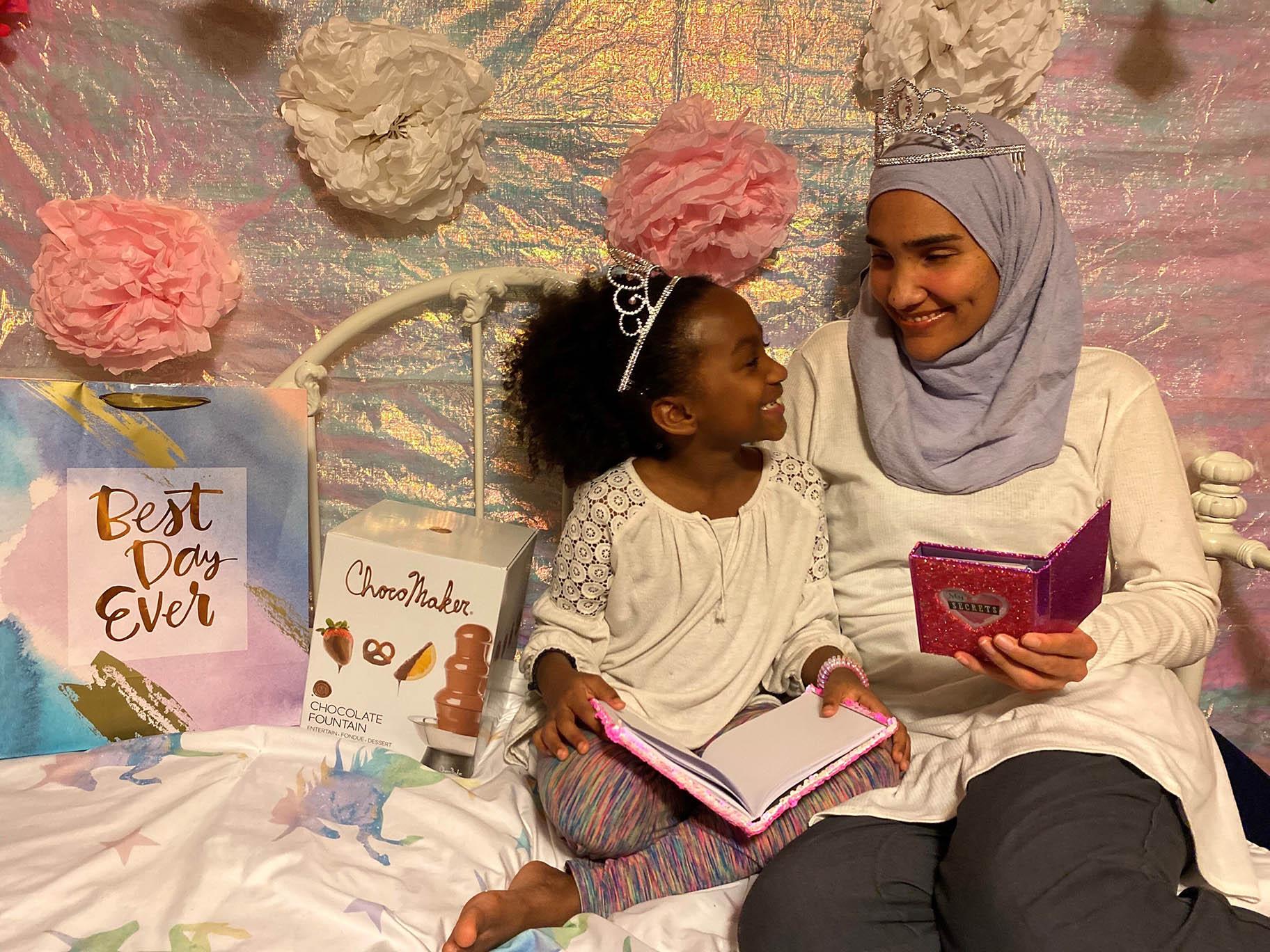 This undated photo shows Melissa Mueller-Douglas and her 7-year-old daughter, Nurah, at their home in Rochester, N.Y. with some of the items they plan to use for a Mother’s Day sleepover. (Yakub Shabazz via AP)