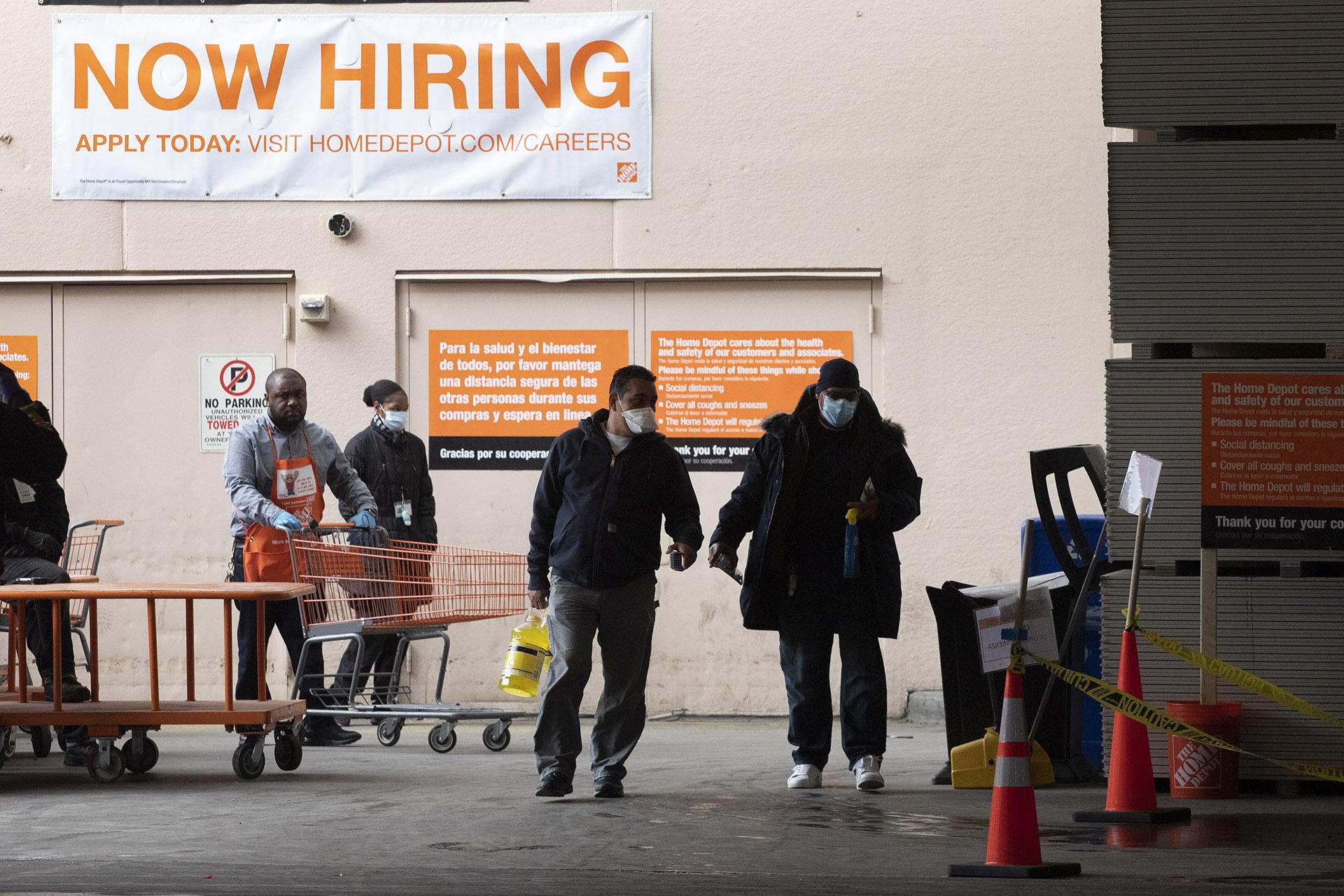 Home Depot customers carry their purchases as they leave the store, Friday, April 3, 2020 during the coronavirus pandemic in New York. (AP Photo / Mark Lennihan)