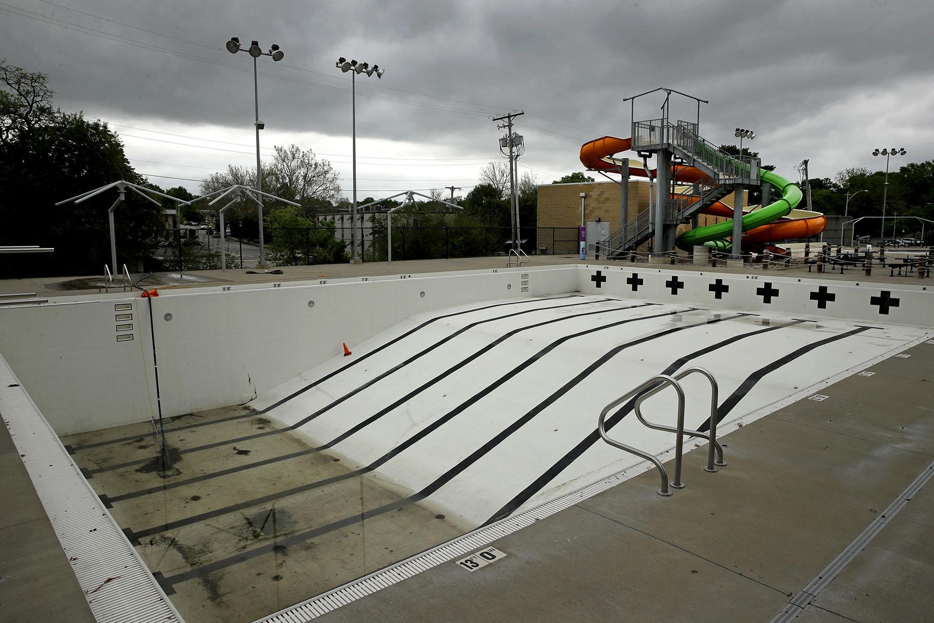 In this photo taken Friday, May 15, 2020, the public pool in Mission, Kan. is lifeless as plans remain in place to keep the pool closed for the summer to help prevent the spread of COVID-19. (AP Photo / Charlie Riedel)