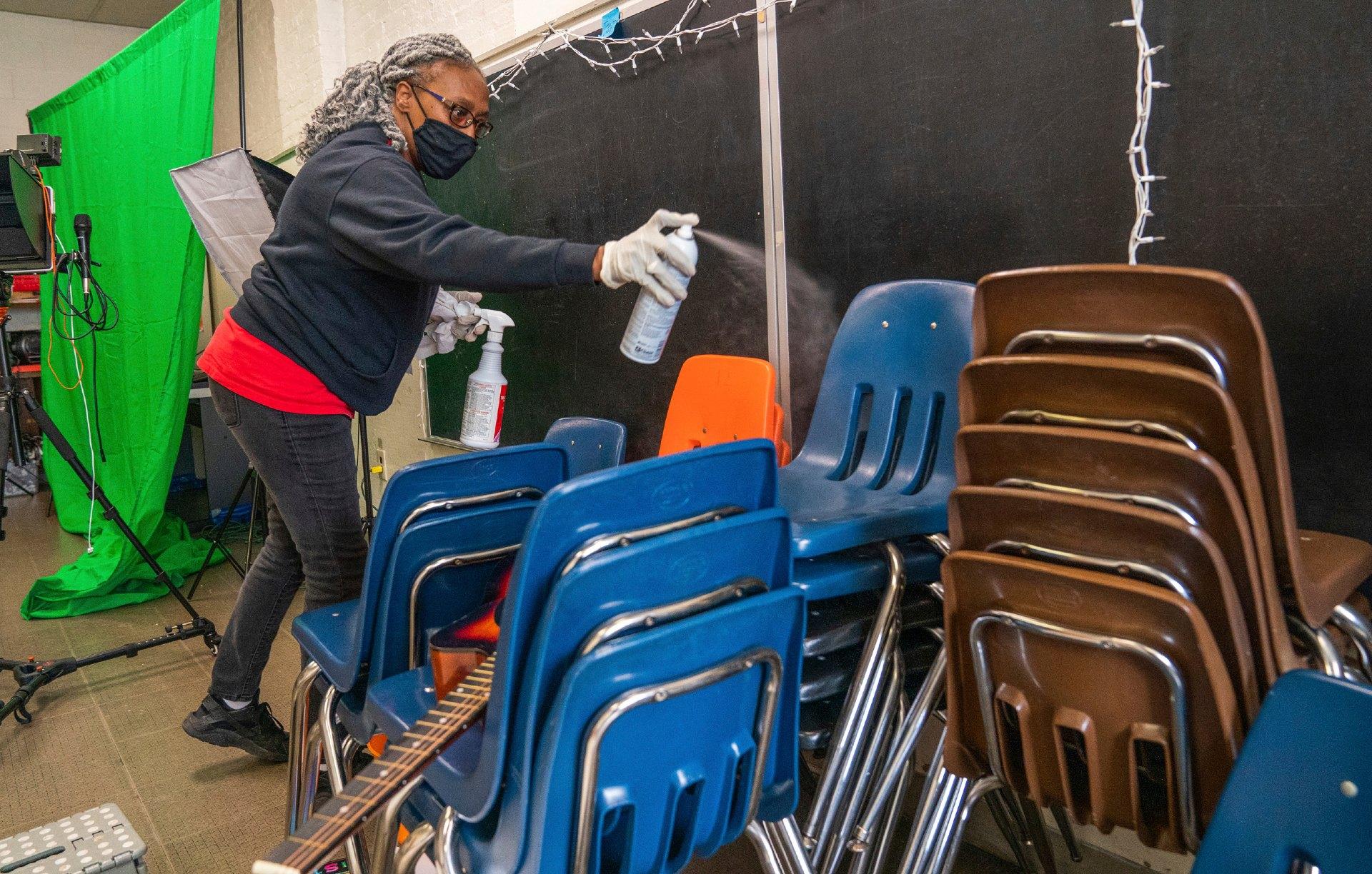 In this Thursday, March 4, 2021, file photo, Latisha Bledsoe cleans chairs in the music room at Manchester Academic Charter School during the coronavirus pandemic in Pittsburgh. The school is planning to return students to the classroom in a hybrid schedule at the end of March. (Andrew Rush / Pittsburgh Post-Gazette via AP, File)