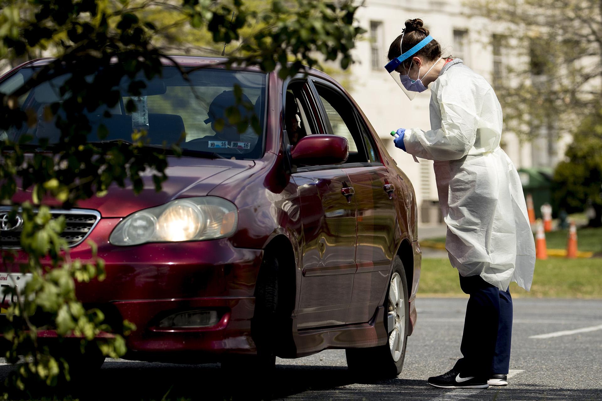 A medical worker prepares to test a young man for COVID-19 at a Children's National Hospital drive-through coronavirus testing site at Trinity University, Thursday, April 16, 2020, in Washington. (AP Photo / Andrew Harnik)