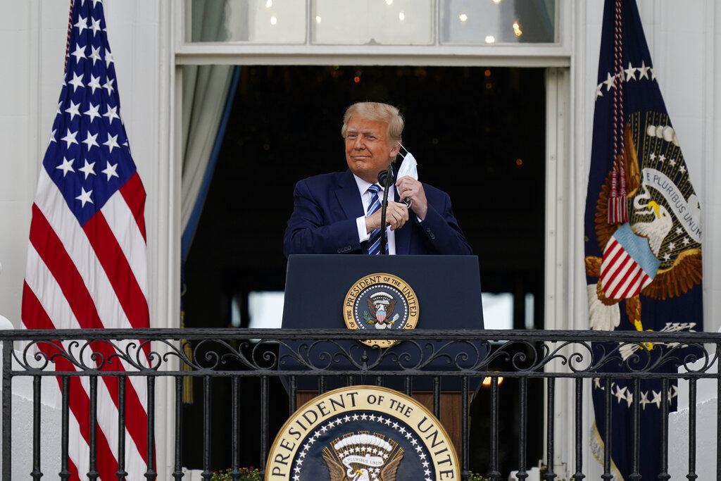 President Donald Trump removes his face mask to speak from the Blue Room Balcony of the White House to a crowd of supporters, Saturday, Oct. 10, 2020, in Washington. (AP Photo / Alex Brandon)