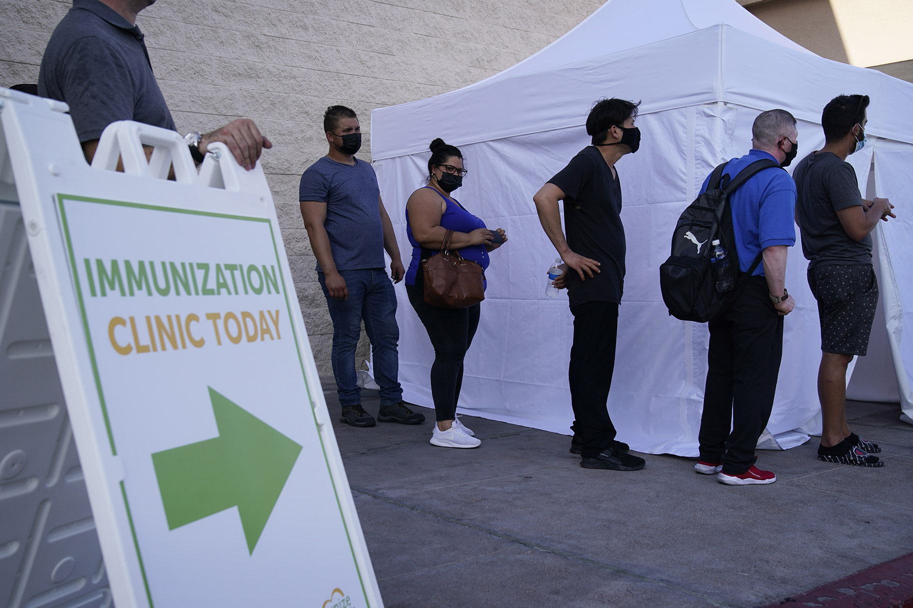 In this Wednesday, July 7, 2021, file photo, people wait in line for COVID-19 vaccinations at an event at La Bonita market, a Hispanic grocery store, in Las Vegas. (AP Photo / John Locher, File)