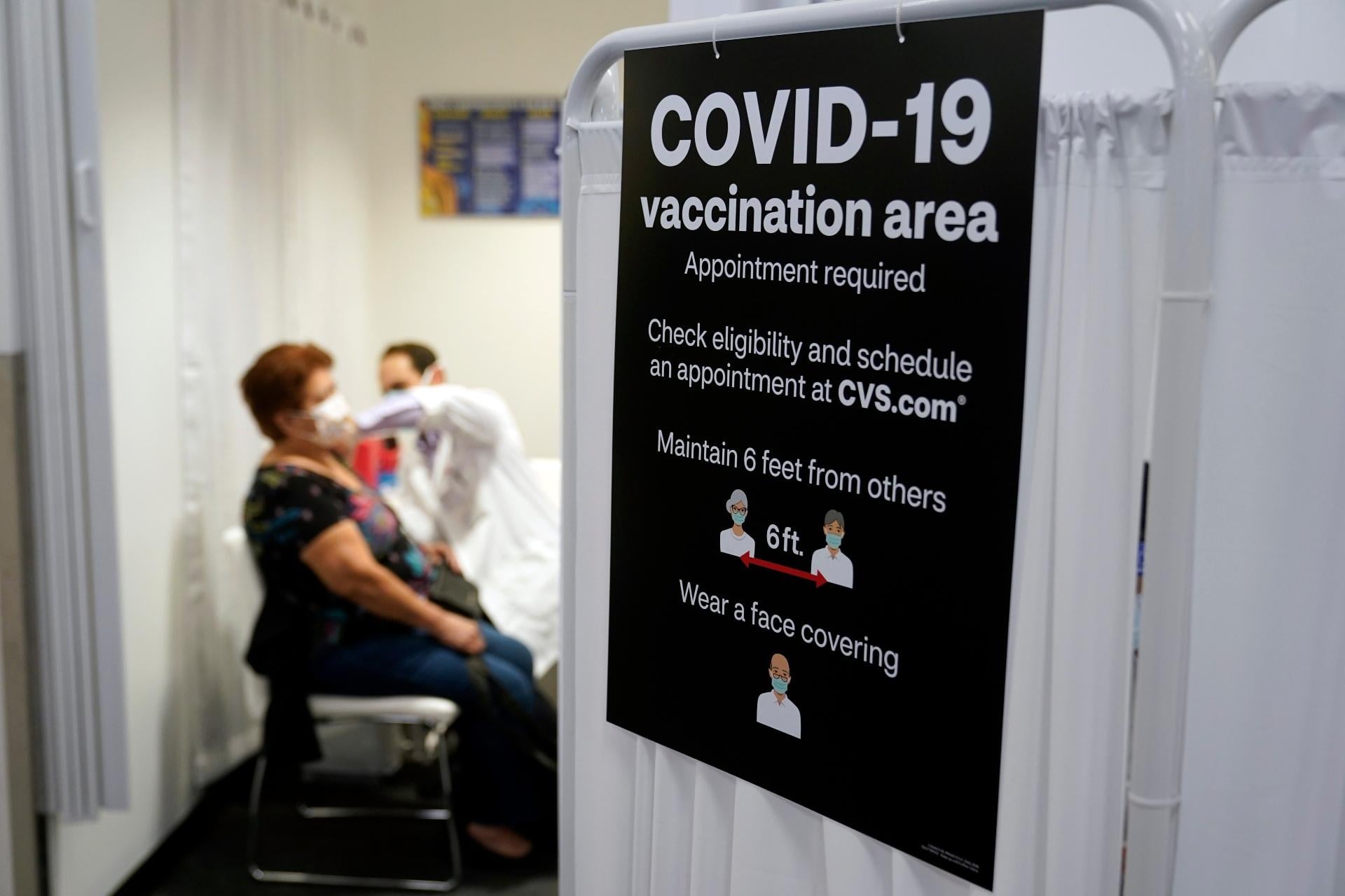 In this March 1, 2021, file photo, a patient receives a shot of the Moderna COVID-19 vaccine next to a guidelines sign at a CVS Pharmacy branch in Los Angeles. (AP Photo / Marcio Jose Sanchez, File)