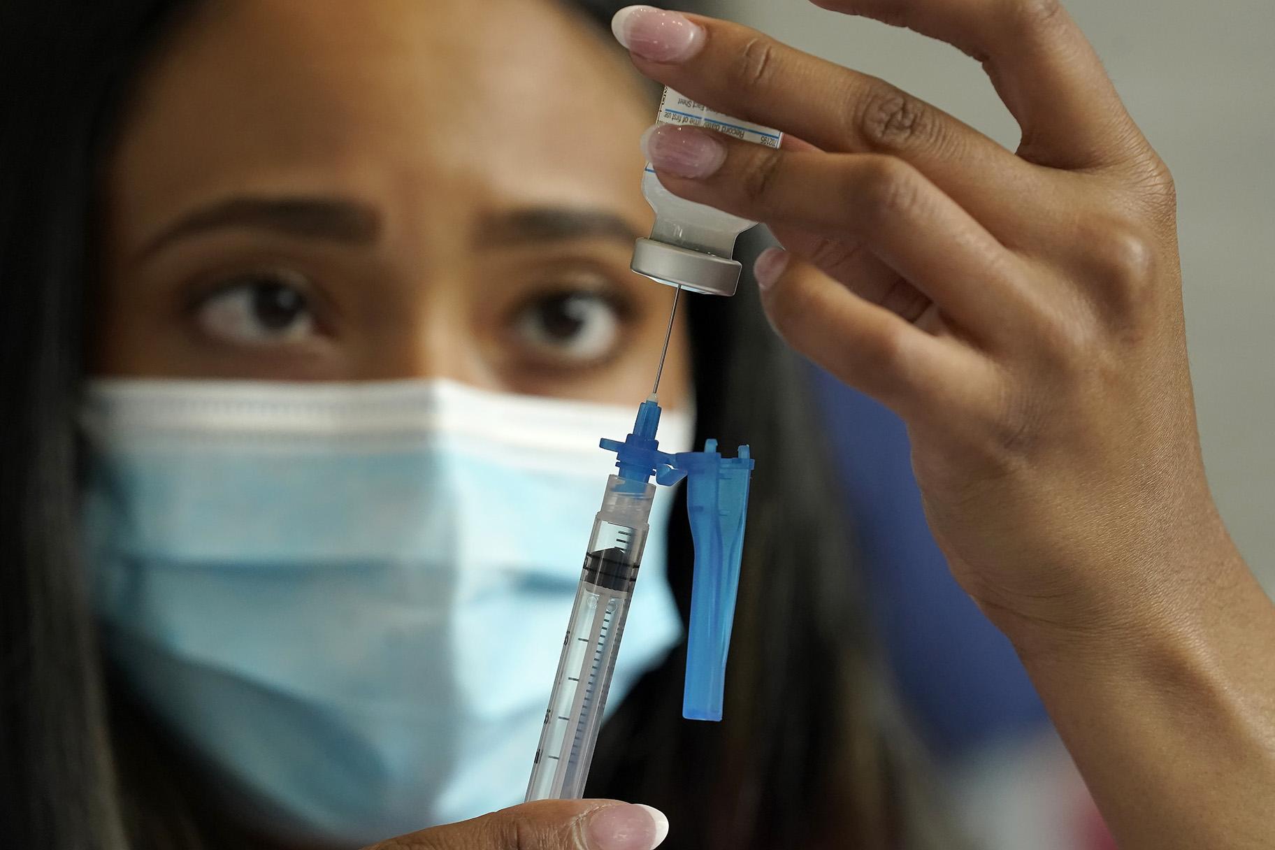 Licensed practical nurse Yokasta Castro, of Warwick, R.I., draws a Moderna COVID-19 vaccine into a syringe at a mass vaccination clinic, Wednesday, May 19, 2021, at Gillette Stadium, in Foxborough, Mass. (AP Photo / Steven Senne)