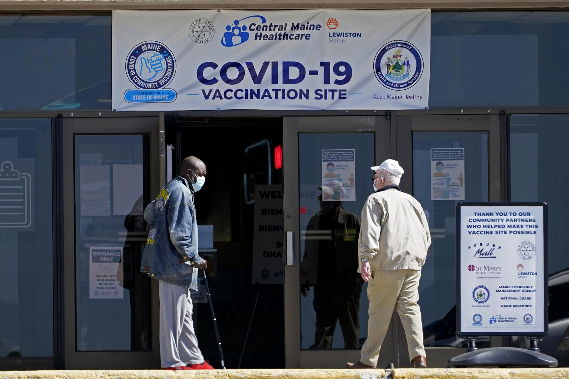 In this May 12, 2021, file photo, one man holds the door for another as they arrive at a COVID-19 vaccination clinic at the Auburn Mall in Auburn, Maine. (AP Photo / Robert F. Bukaty)