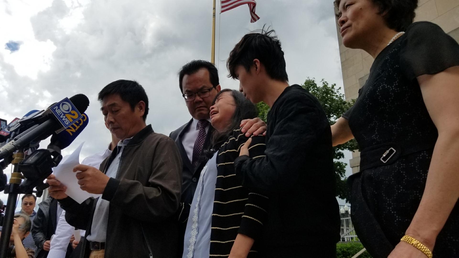 Yingying Zhang’s father, Ronggao Zhang, reads a statement in Chinese outside the federal courthouse in Peoria, Illinois, on Monday, June 24, 2019, moments after a 12-person jury found Brendt Christensen guilty of her kidnapping and death. Yingying Zhang’s mother, Lifeng Ye, sobs as her husband addresses the media. (Matt Masterson / WTTW News)
