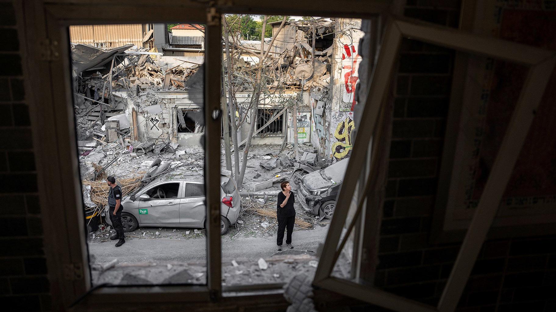 Israelis inspect the rubble of a building a day after it was hit by a rocket fired from the Gaza Strip, in Tel Aviv, Israel, on Sunday. (Oded Balilty / AP)