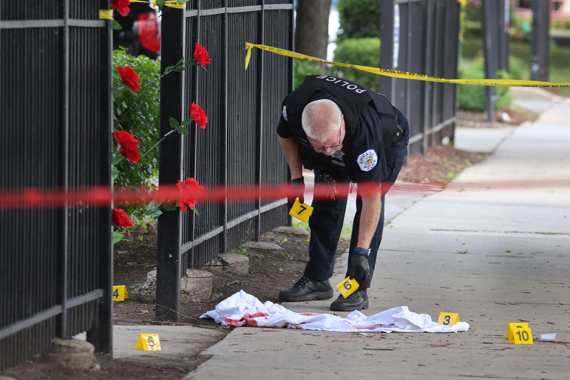 Police investigate a crime scene where three people were shot — one fatally — in the Bridgeport neighborhood on June 23 in Chicago. (Scott Olson / Getty Images)
