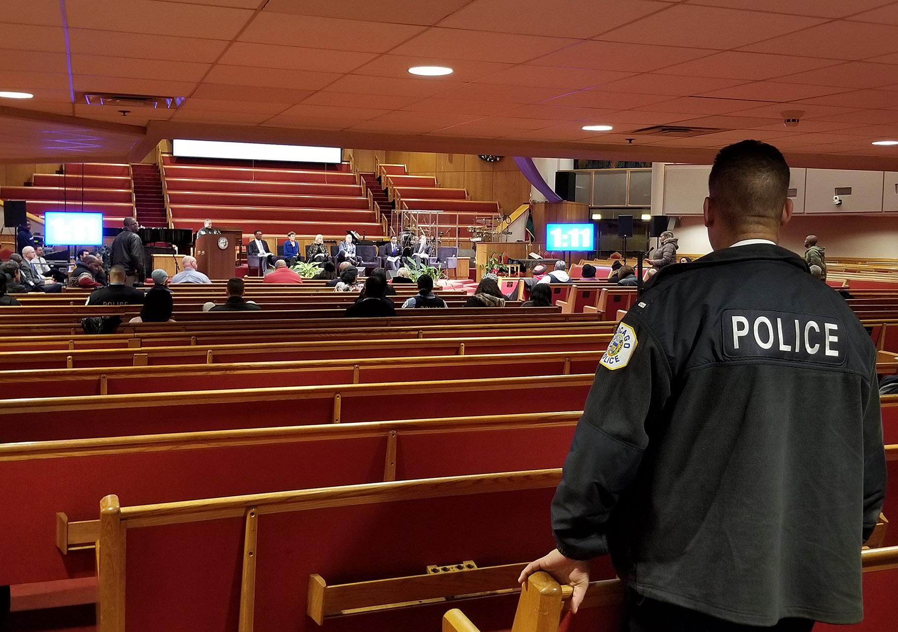 A Chicago police officer looks on during Monday’s police board listening session at the Trinity United Church of Christ. (Matt Masterson / WTTW News)