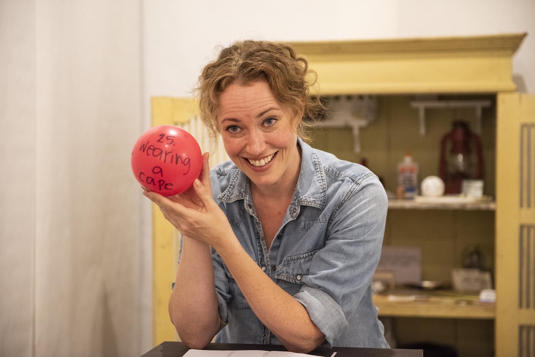 Rebecca Spence holds up a red balloon in “Every Brilliant Thing.” (Photo credit: Michael Brosilow)