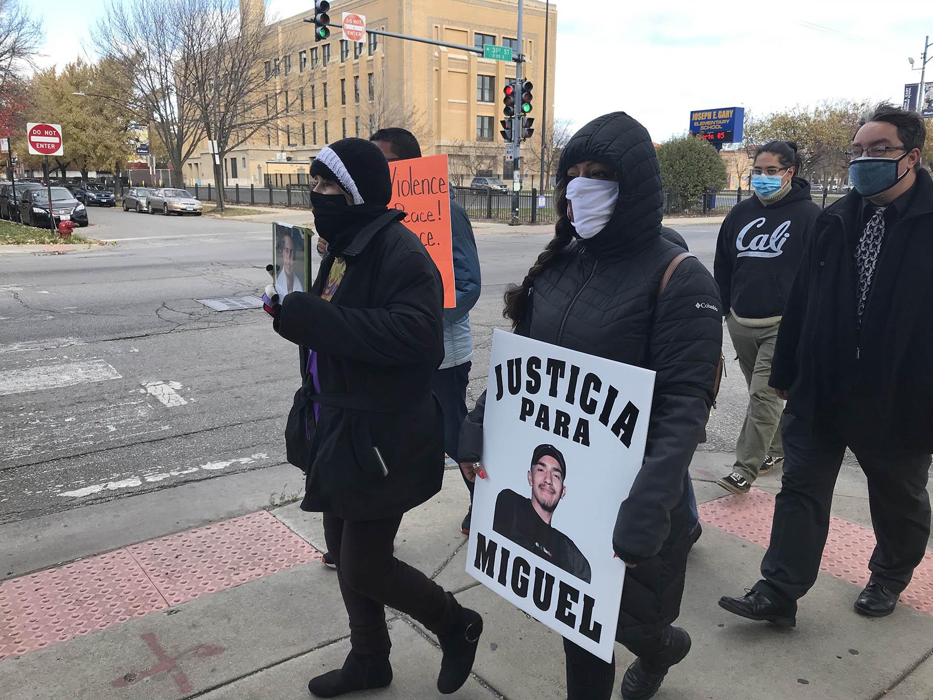 The families of Frank Aguilar and Miguel Rios, both victims of gun violence, chant “No justice, no peace,” in English and Spanish on Sunday, Nov. 1, 2020 in Little Village along with organizers of the march. (Ariel Parrella-Aureli / WTTW News)