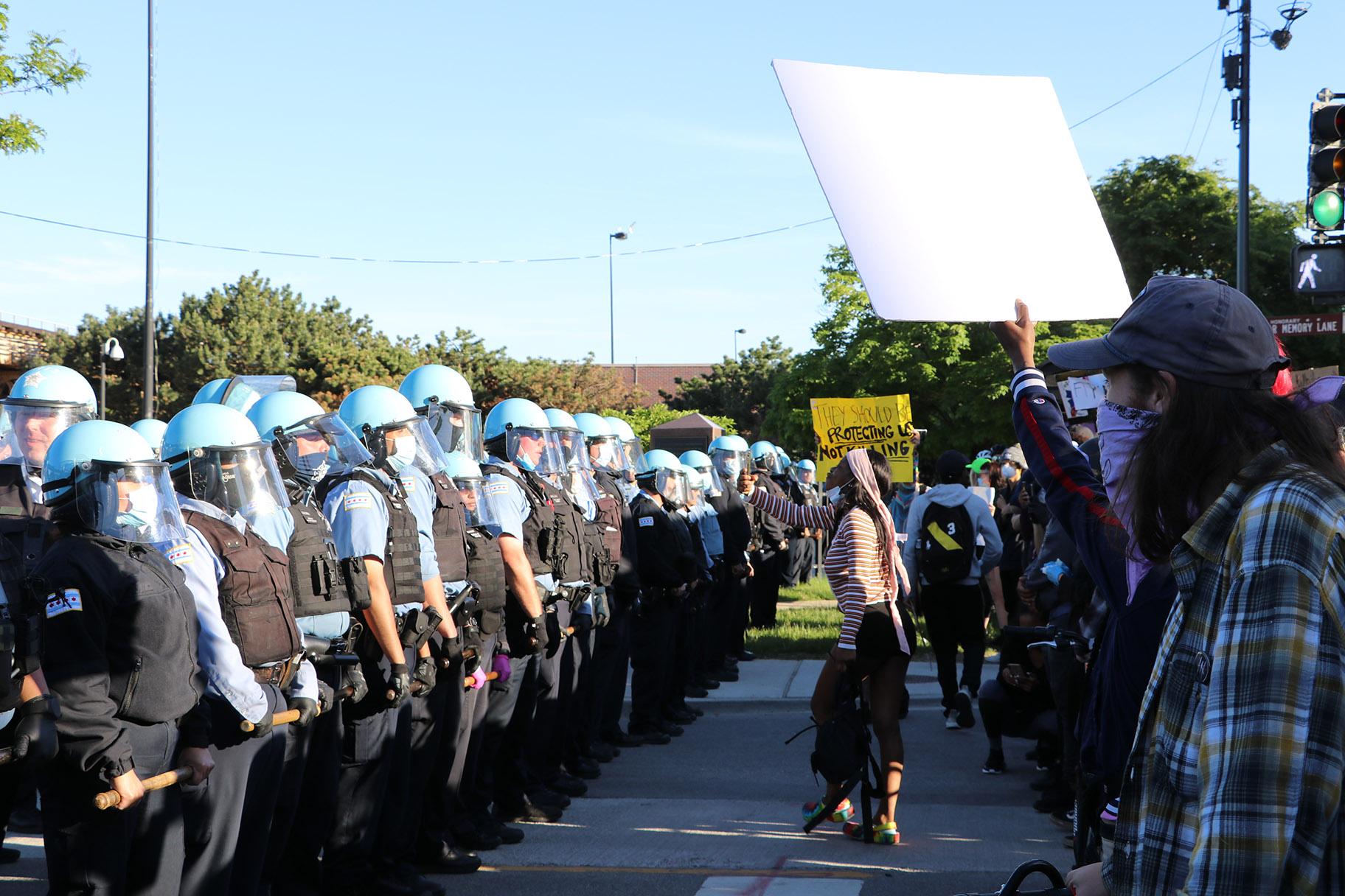 Protesters yell at a line of police officers at State and 35th streets, about 3 miles south of the Loop, where police set up a blockade on Sunday, May 31, 2020. (Evan Garcia / WTTW News)