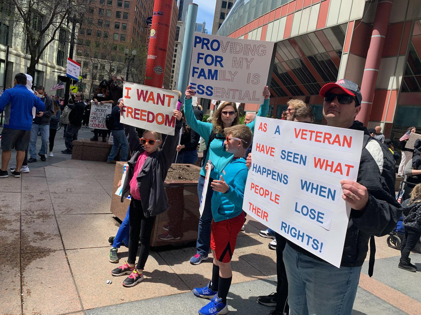 Patrick and Karen Swearingen and their four children protest Gov. J.B. Pritzker’s stay-at-home order Friday outside the Thompson Center. (Heather Cherone / WTTW News)