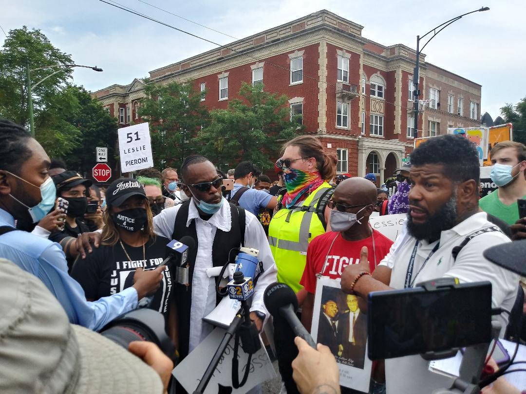 Members of the Chicago Activist Coalition for Justice, led by Rabbi Michael Ben Yosef (center, in white shirt with black vest), speak with the media at a protest against police brutality on Saturday, Aug. 15, 2020 in Chicago. (Annemarie Mannion / WTTW News)